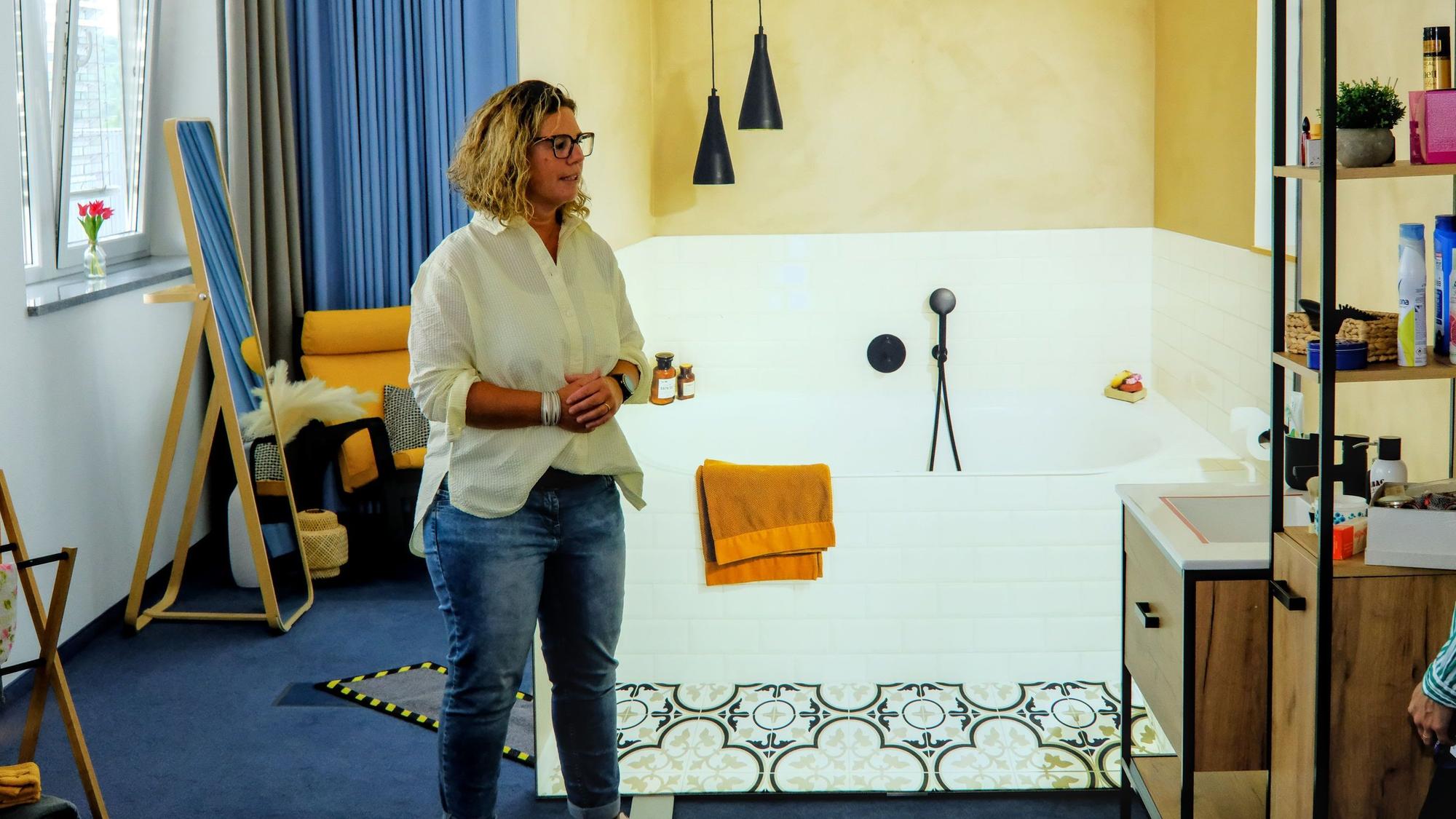 Stefanie Froitzheim, Leiterin AOK Servicestelle Demenz, steht in einer Musterwohnung für Demenzerkrankte mit offenem Badbereich.