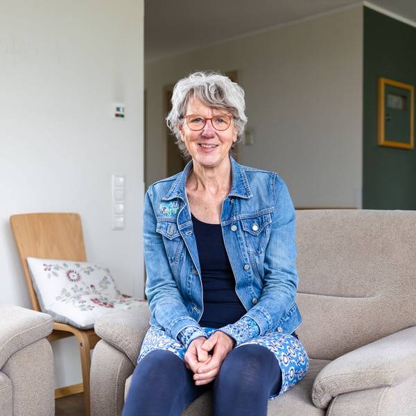 Eine Frau in Jeansjacke lächelt in die Kamera.