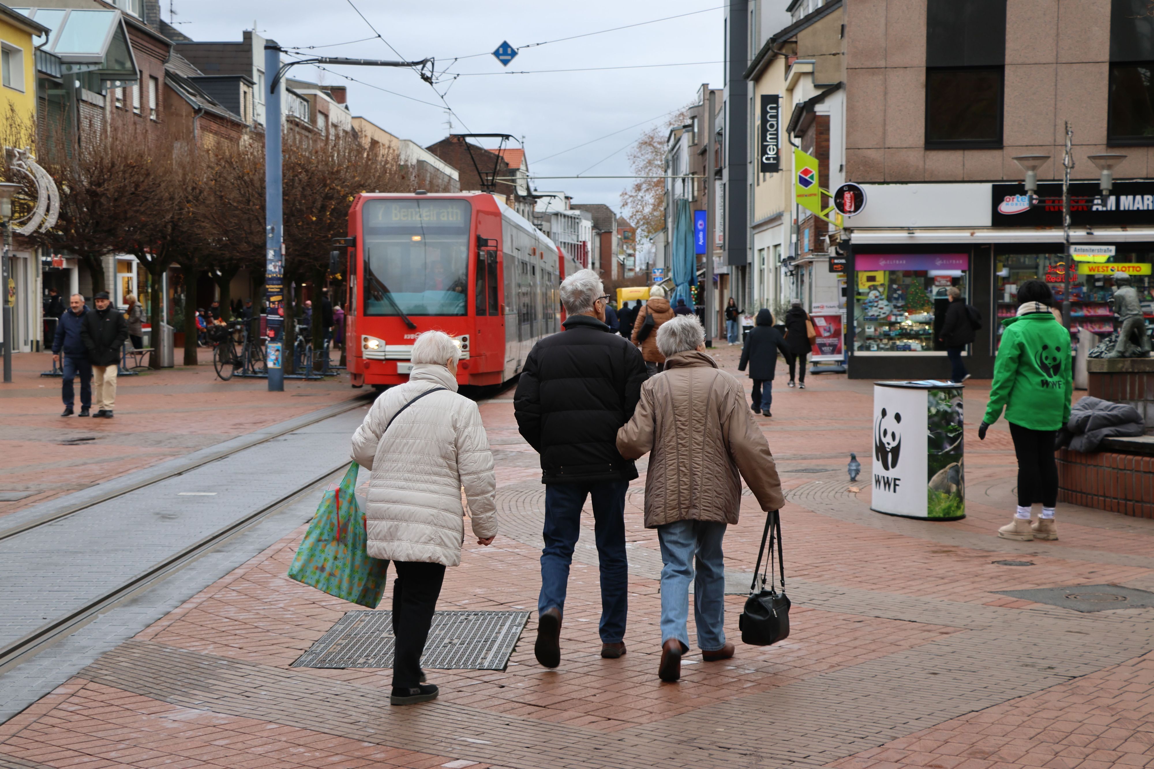 Auf dem Bild ist eine Straßenbahn zu sehen, die durch die Fußgängerzone fährt.