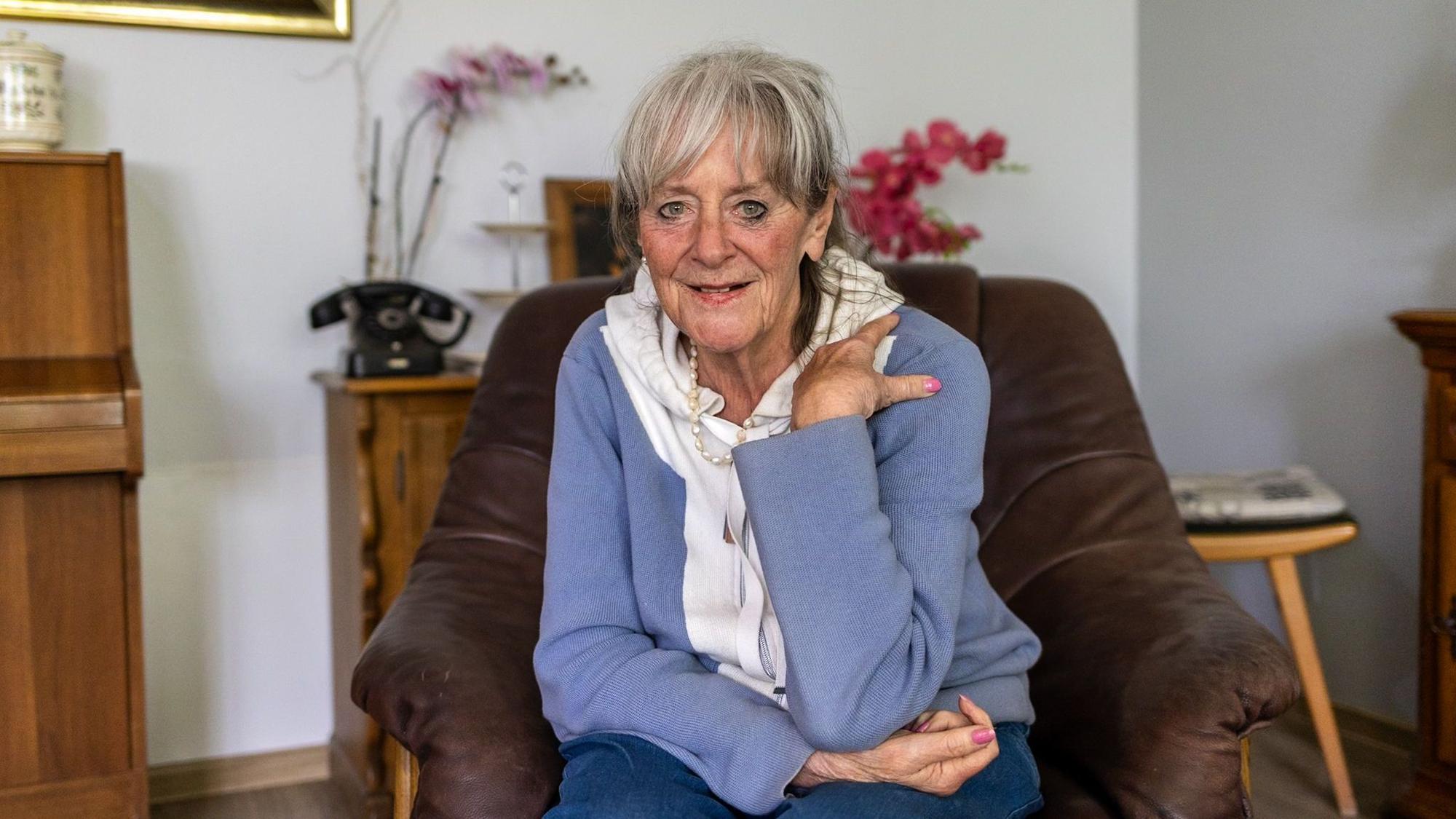 Eine Frau in blauer Jacke blickt in die Kamera