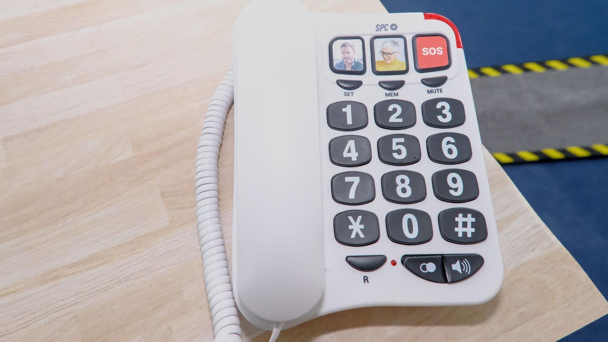 Ein Tastentelefon zeigt Bilder von Menschen, die angerufen werden können.