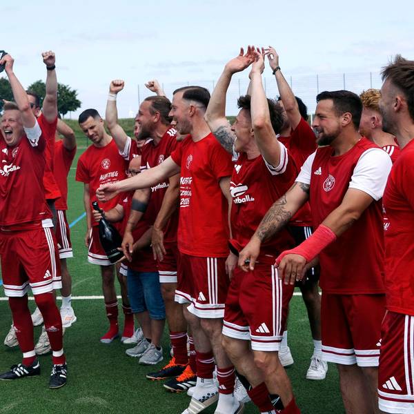 Zülpich-II-Kapitän Jakob Raudszus reißt die Kreismeister-Plakette in die Höhe, der Rest der Mannschaft jubelt mit ihm.
