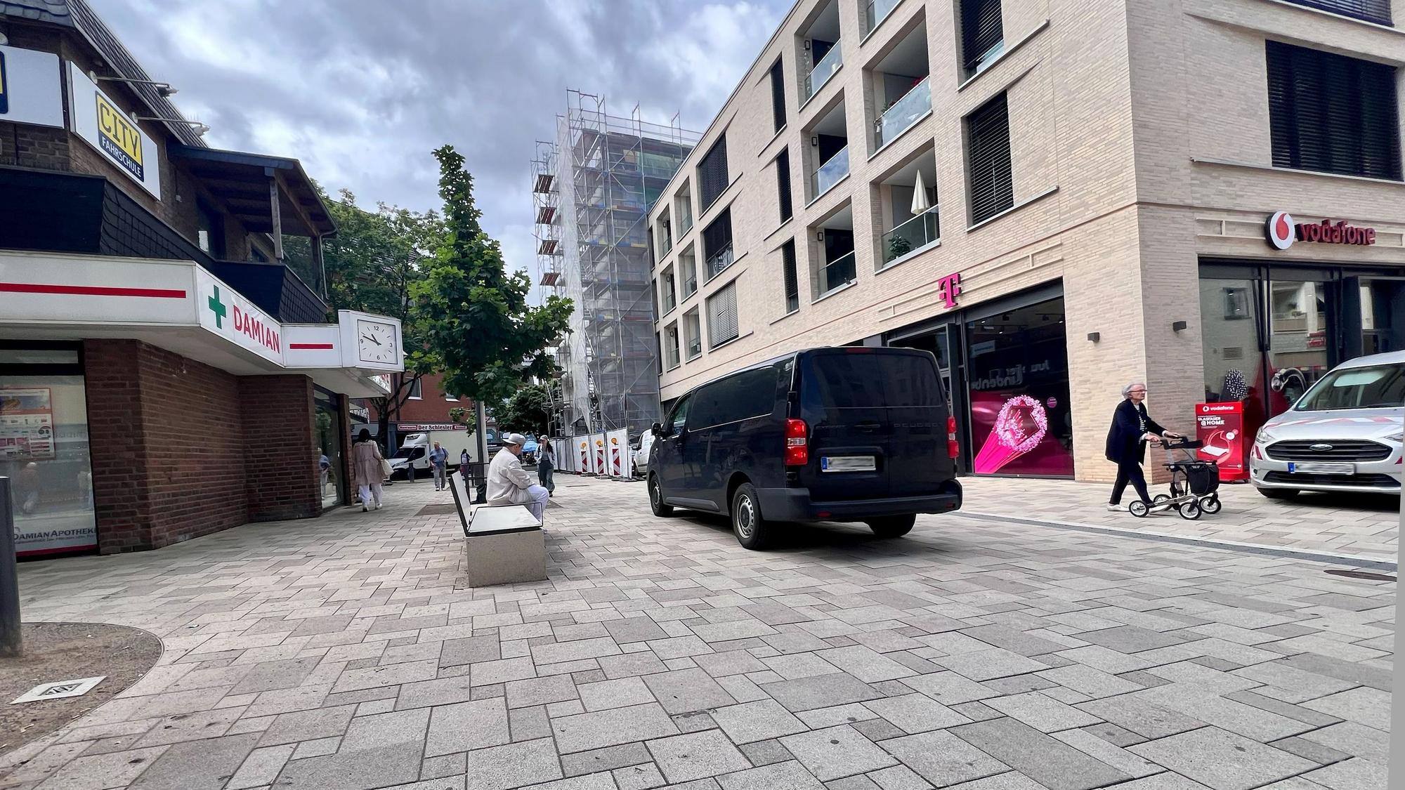Mehrere Autos fahren in der Fußgängerzone der Porzer Innenstadt.