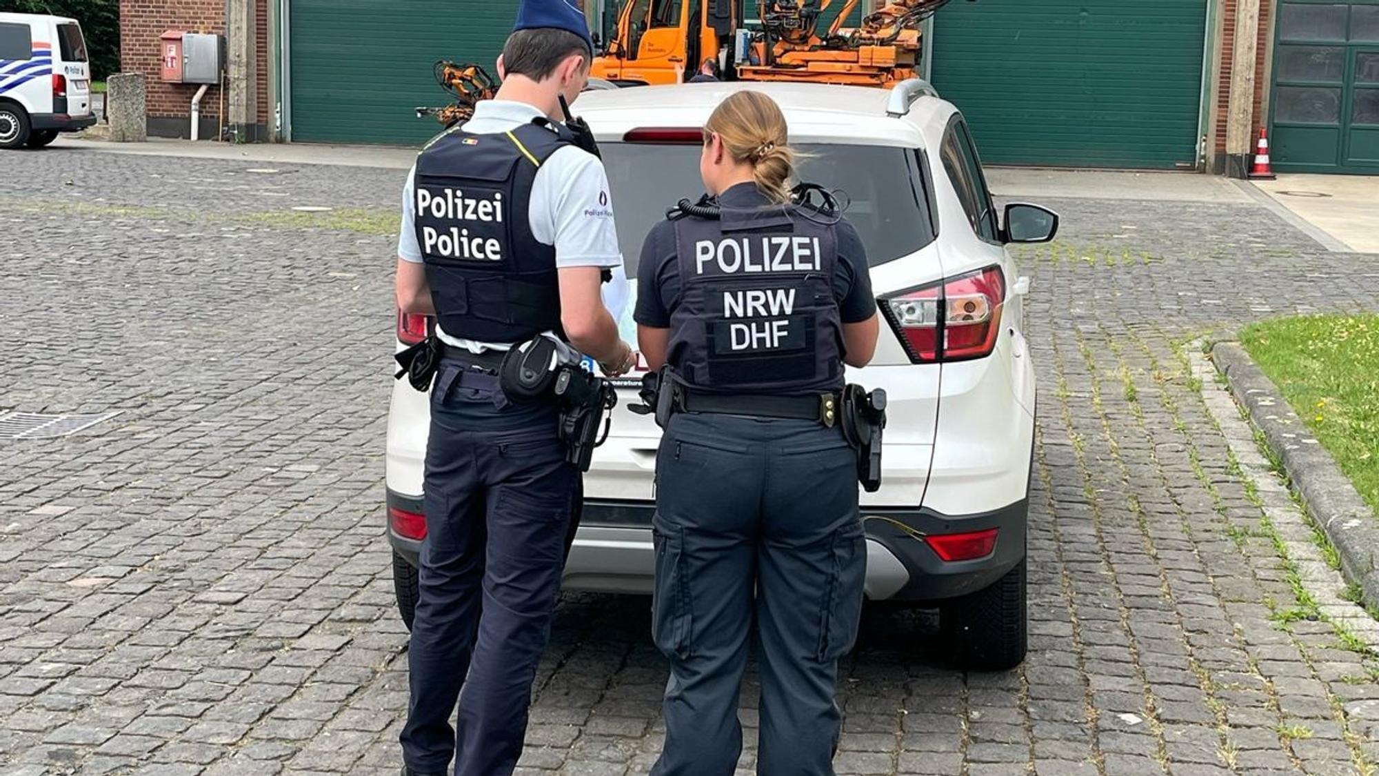 Polizisten und Polizistinnen kontrollieren ein Auto bei einer großangelegten Verkehrskontrolle.