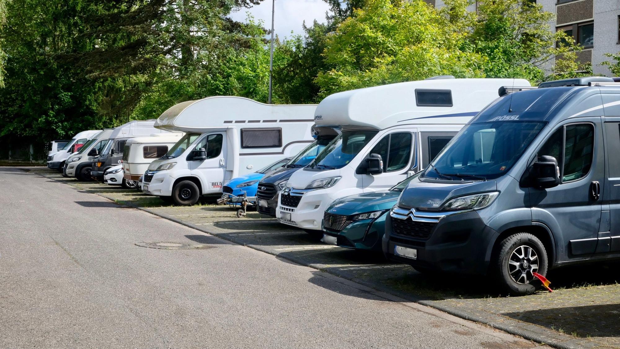 Viele Wohnmobile stehen auf einem Parkplatz nebeneinander.