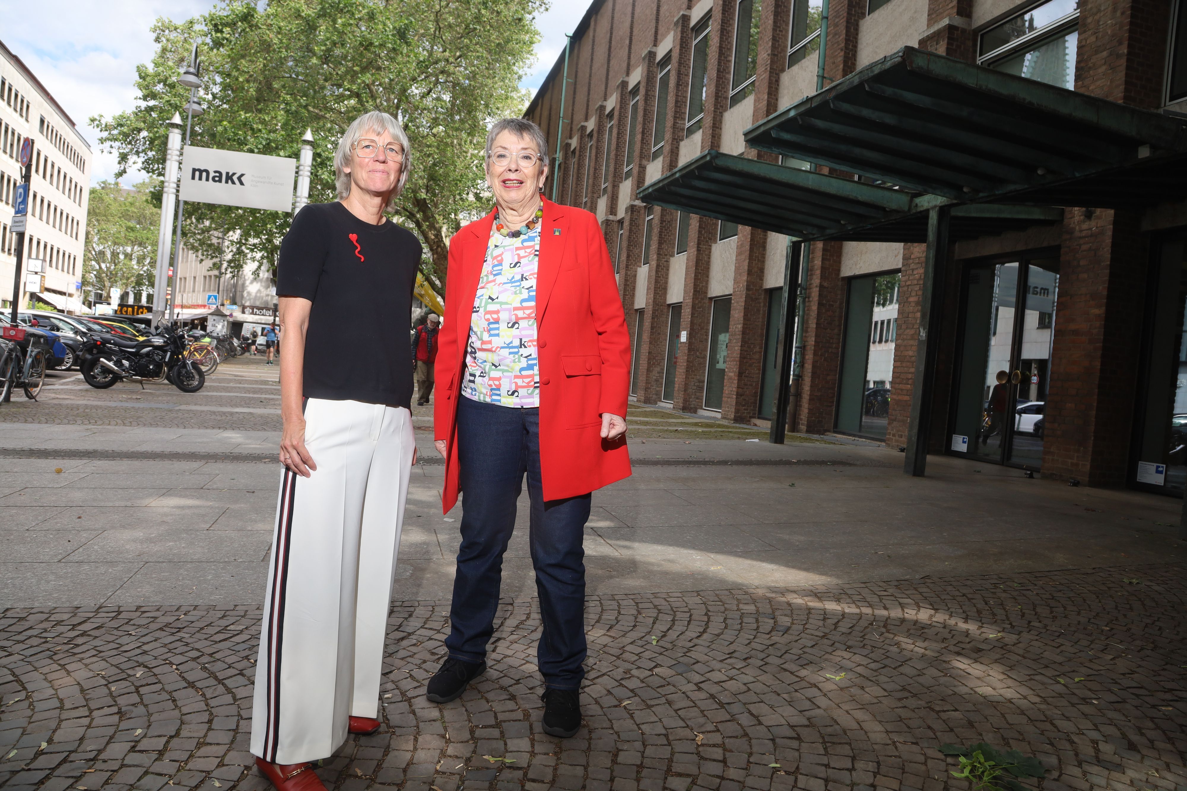 Petra Hesse (links), Direktorin des Museums für Angewandte Kunst Köln (MAKK), und Dombaumeisterin a.D. Barbara Schock-Werner vor der Museumsfassade. Anfang Juni wurden Sperrgitter und ein Sicherheitsdach über dem Eingang entfernt.