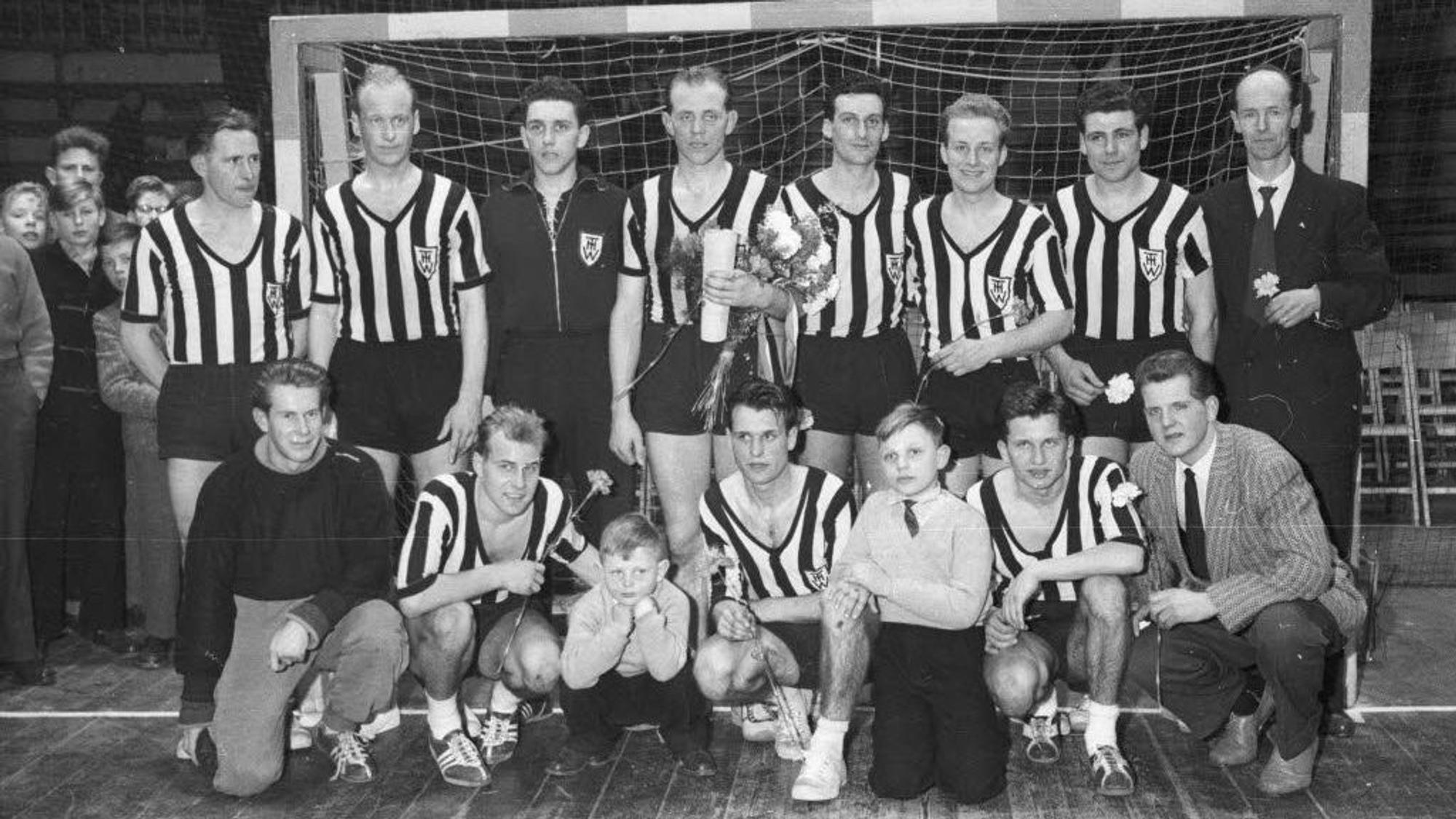 Ein Schwarz-Weiß-Foto, junge Männer in gestreiften Trikots, aufgestellt für ein Mannschaftsbild