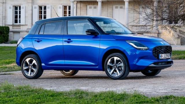 Suzuki Swift 1.2 Club in Blau steht vor einem schönen Haus.