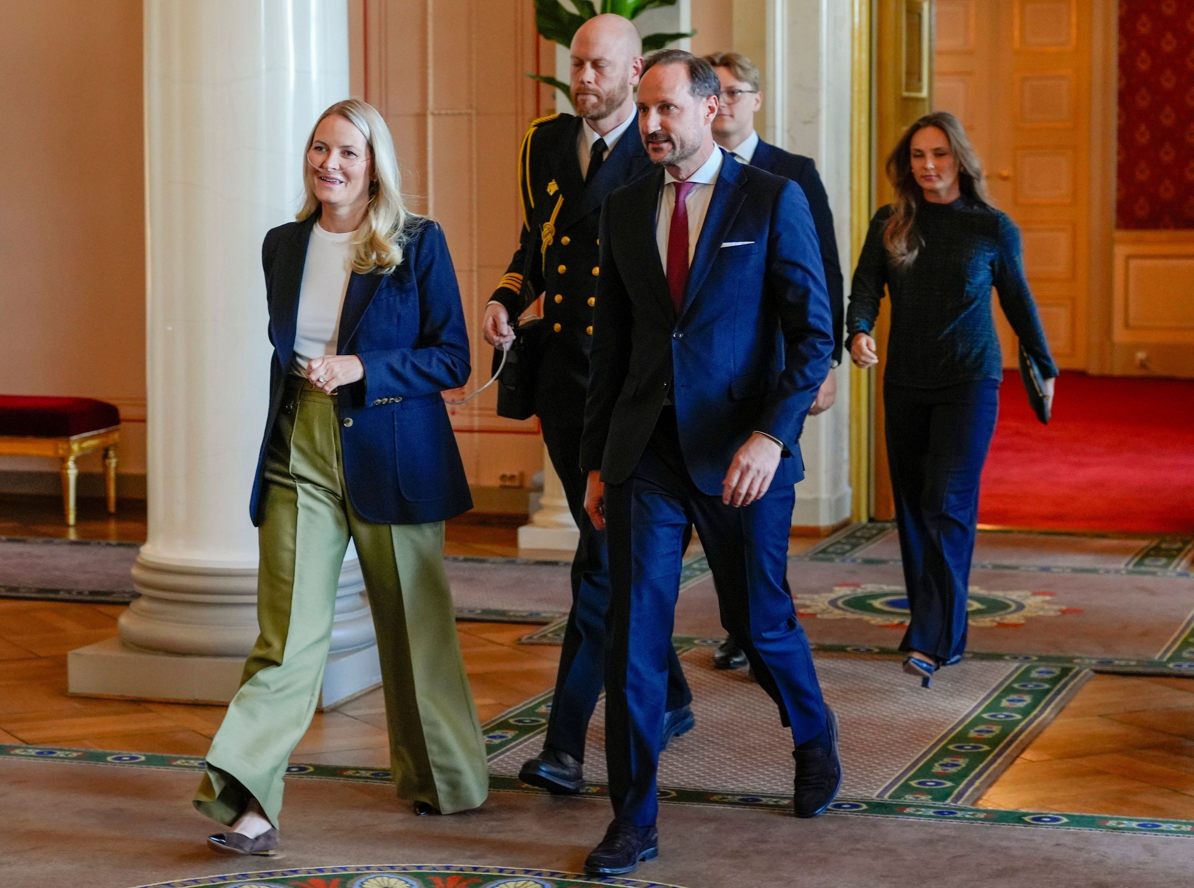 Die norwegische Kronprinzessin Mette-Marit trägt im April 2026 neben Kronprinz Haakon (vorn, r) zum ersten Mal ein Sauerstoffgerät zu einem offiziellen Termin bei einem Empfang für die norwegischen Athleten der Paralympics in Mailand und Cortina 2026.
