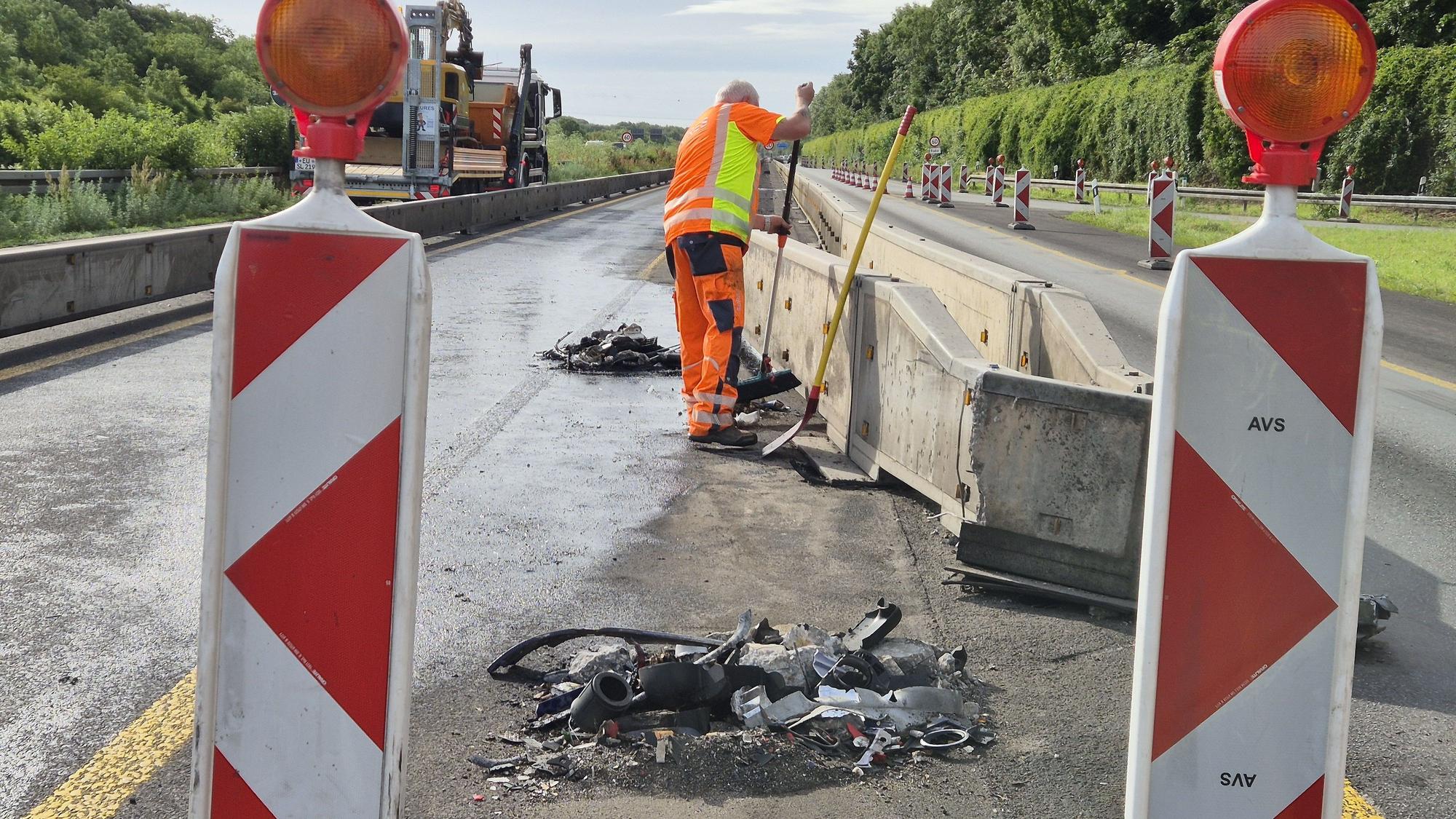 Ein Mitarbeiter kehrt Trümmerteile an der Baustelle zusammen. Nach einem nächtlichen Lkw-Unfall bei Köln-Klettenberg war die Autobahn 4 in Richtung Oberhausen am Morgen bis zum Kreuz Köln-West voll gesperrt.