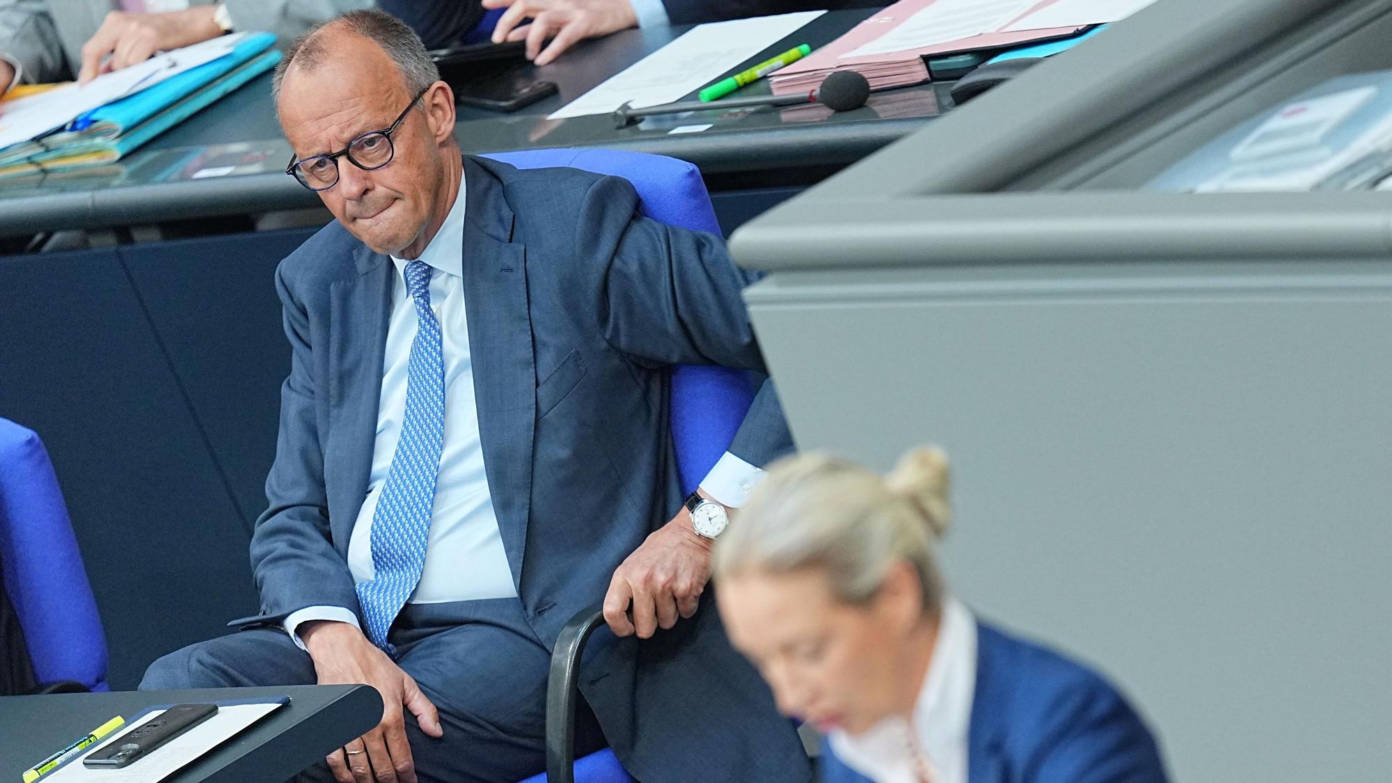 Bundeskanzler Friedrich Merz hört Alice Weidel aufmerksam zu.