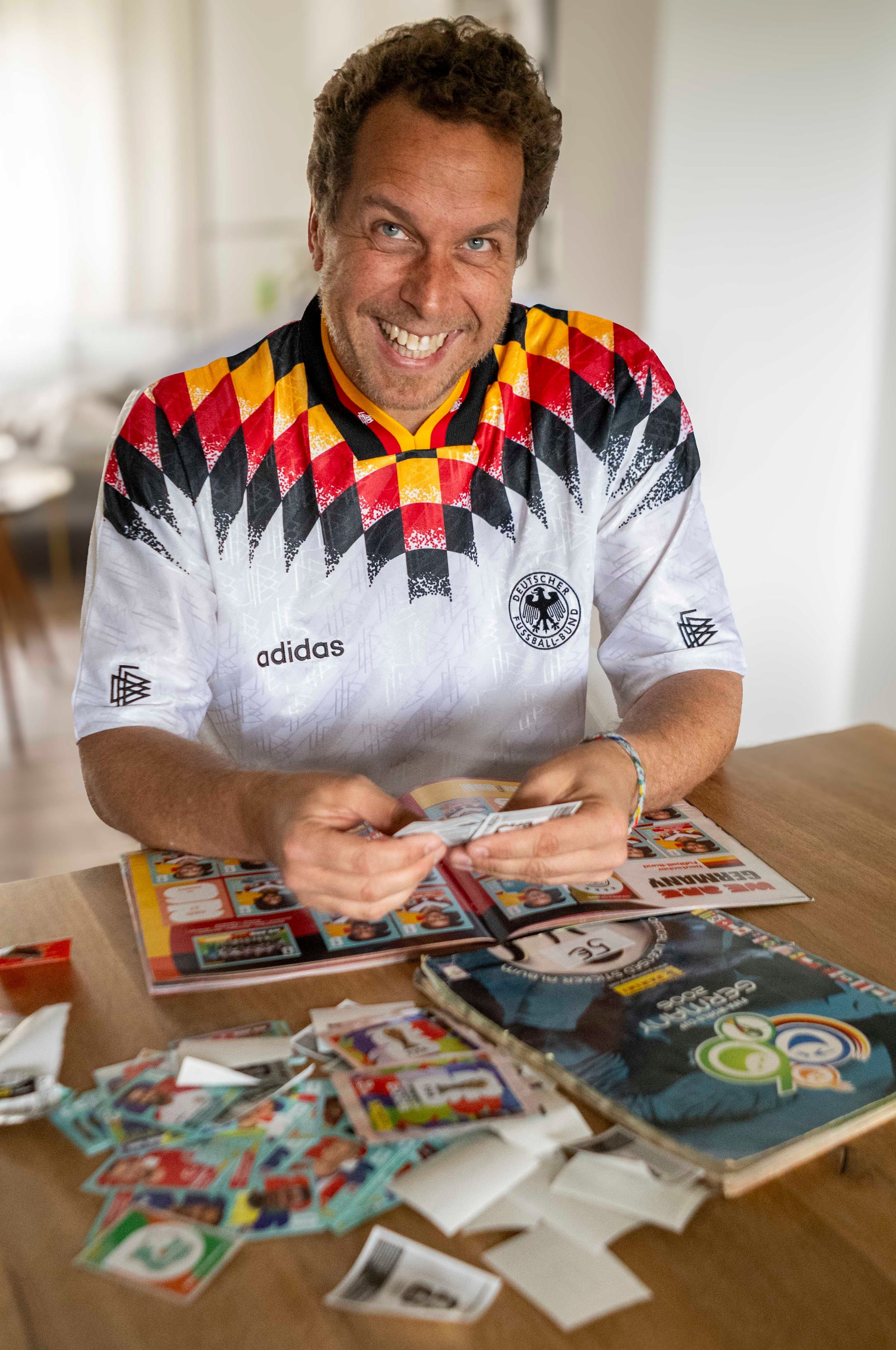 Tom Steinicke im WM-Trikot von 1994 klebt Panini-Bilder ein.