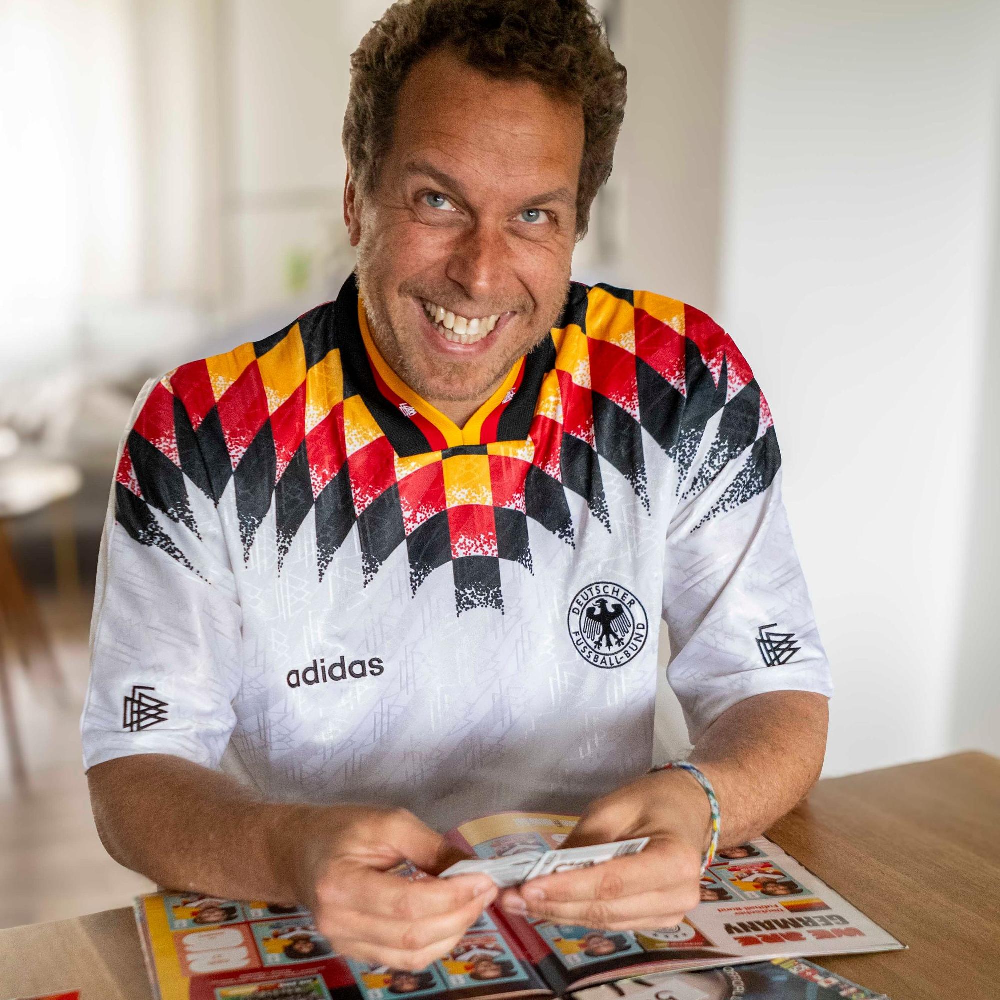 Tom Steinicke im WM-Trikot von 1994 klebt Panini-Bilder ein.