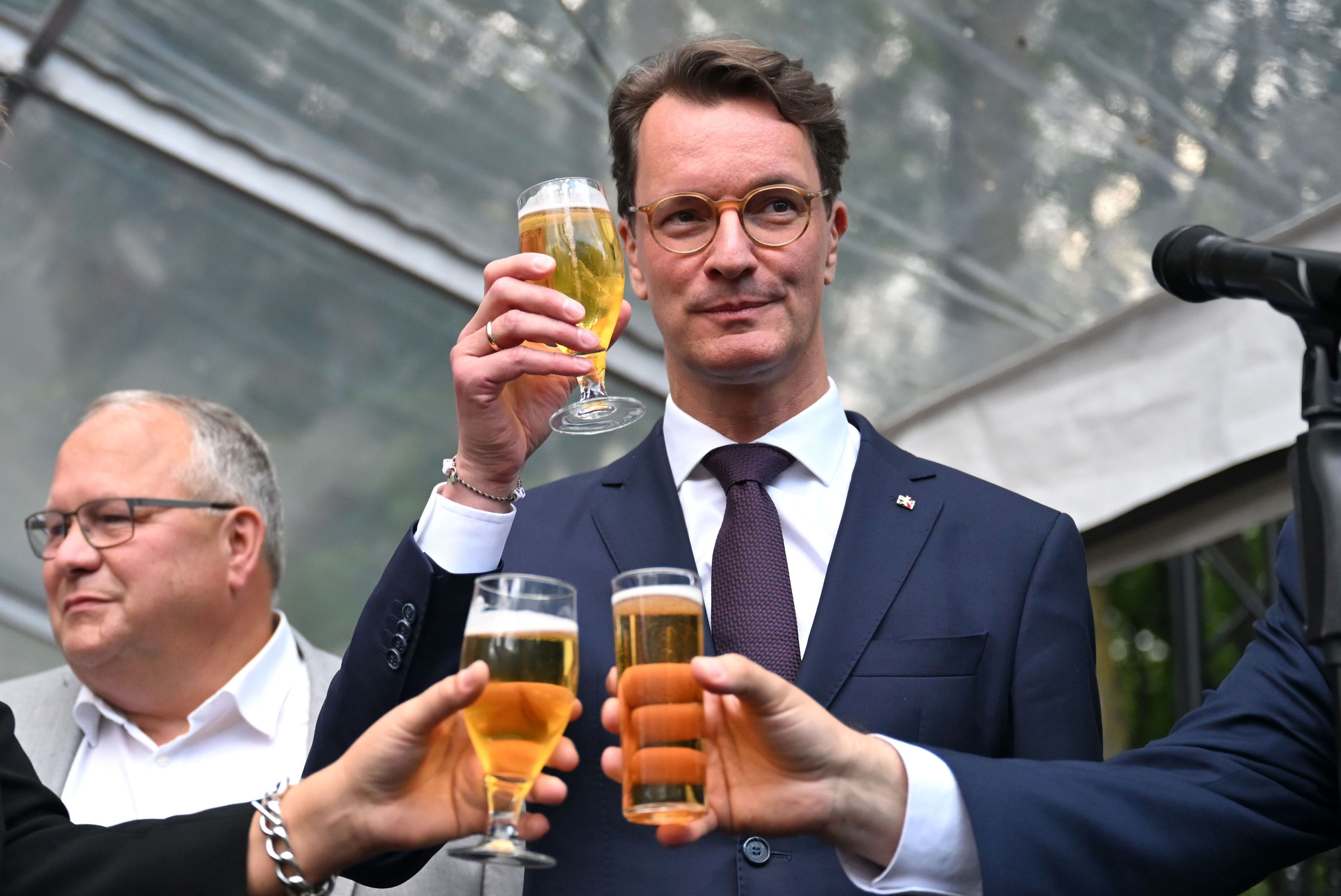 Hendrik Wüst (CDU), Ministerpräsident von Nordrhein-Westfalen, stößt beim Sommerfest der Landesvertretung Nordrhein-Westfalen mit Kollegen an.