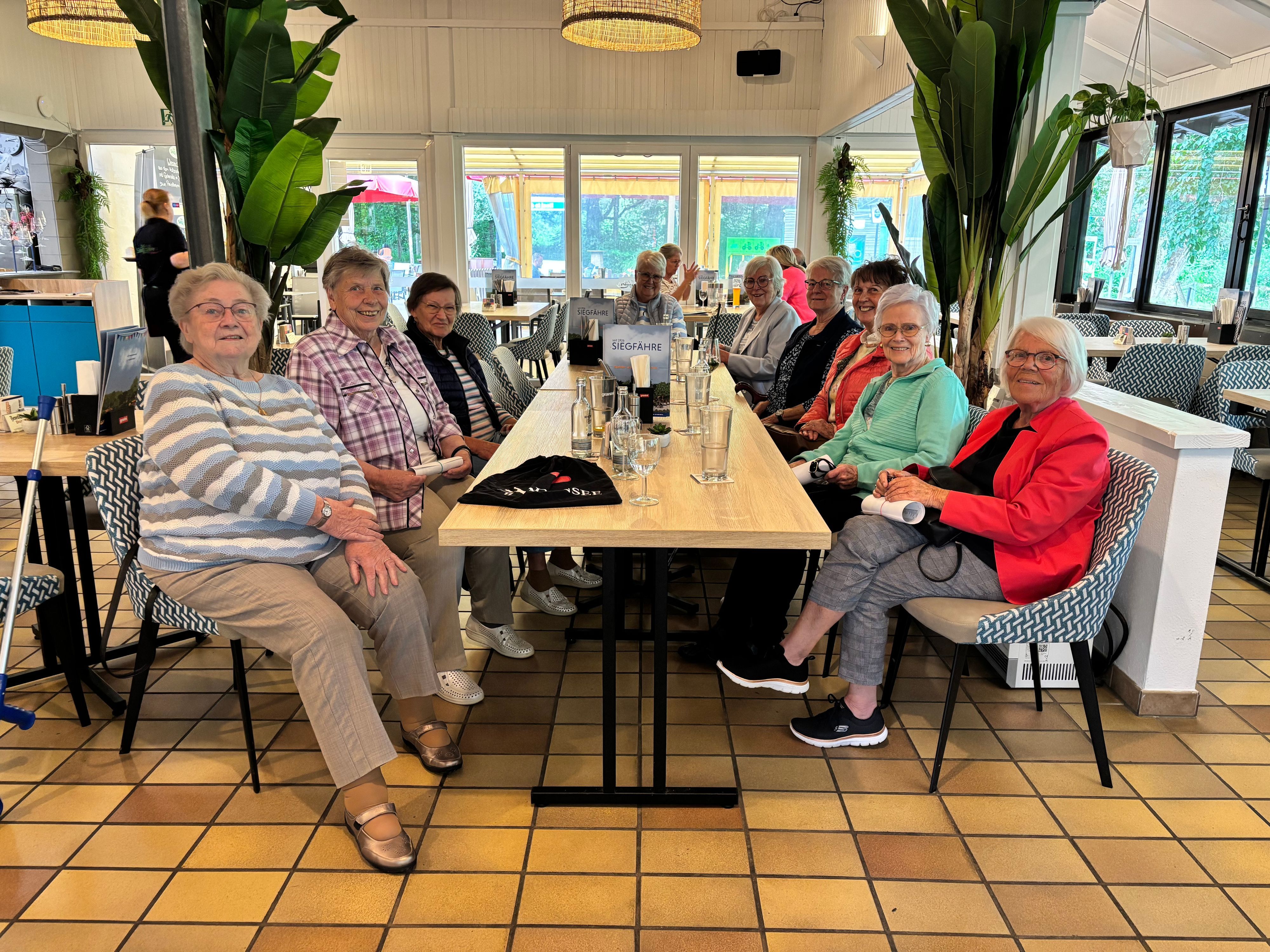 Eine Gruppe Seniorinnen sitzt an zwei zusammengeschobenen Tischen im Restaurant „Zur Siegfähre“.