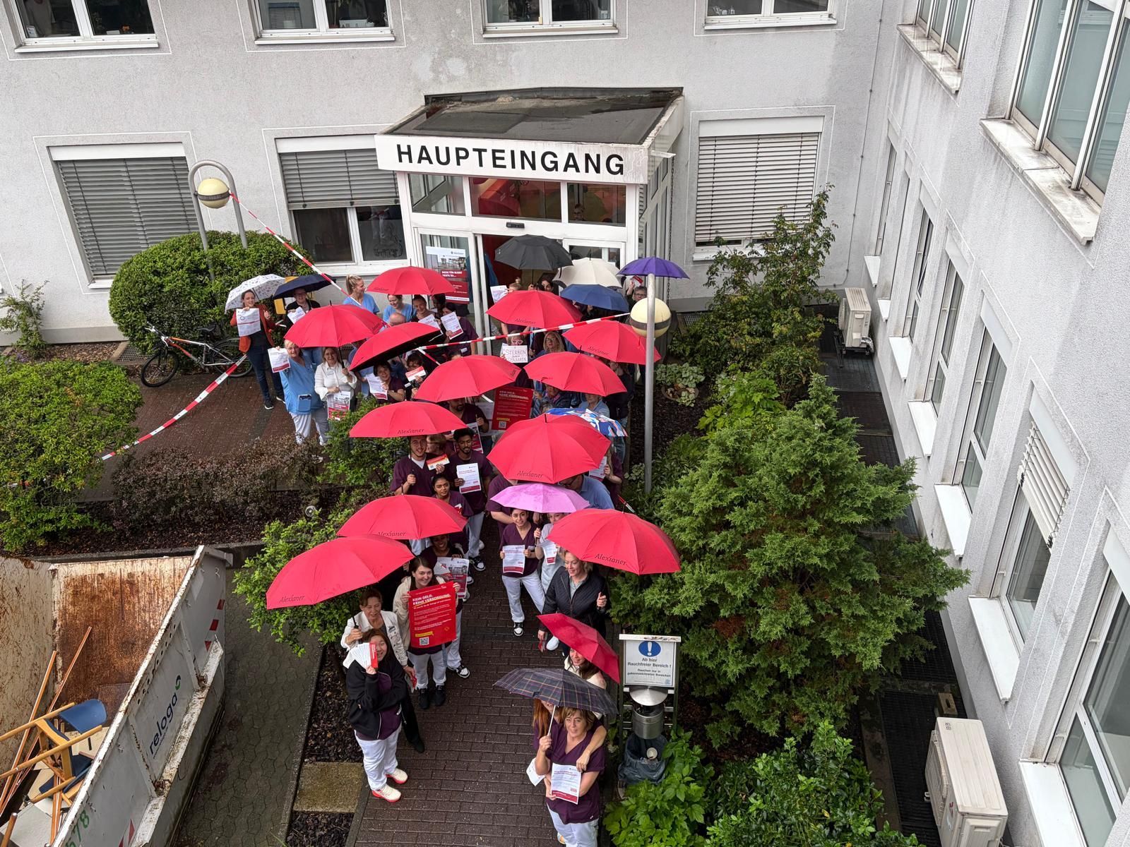 Trotz Regen protestieren die Mitarbeitenden des St.-Remigius-Krankenhauses für eine starke Krankenhausversorgung.