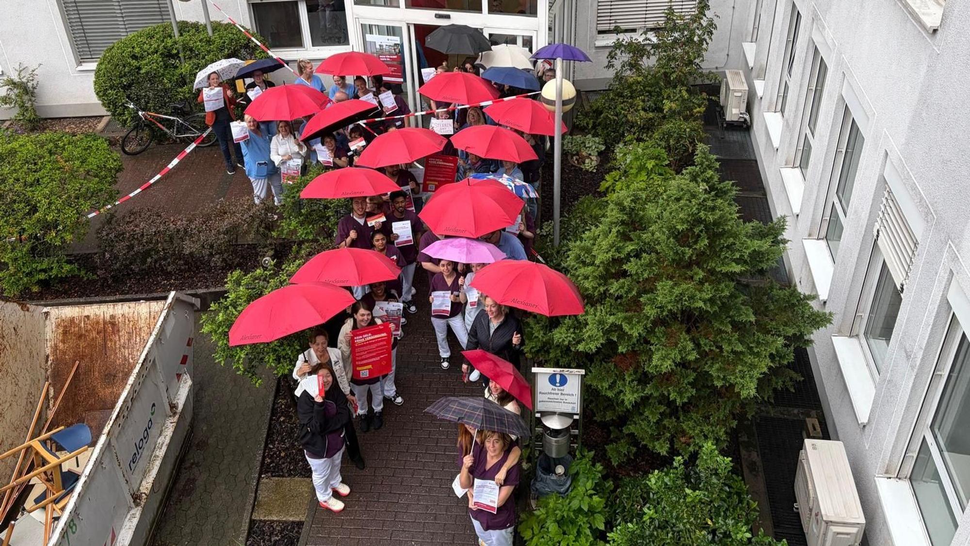 Trotz Regen protestieren die Mitarbeitenden des St.-Remigius-Krankenhauses für eine starke Krankenhausversorgung.