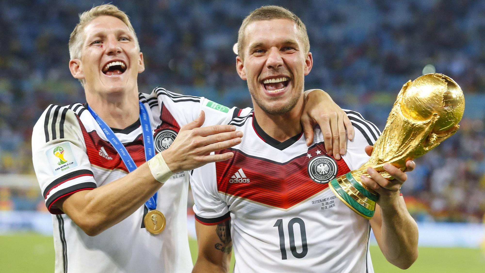 Lukas Podolski und Bastian Schweinsteiger (l.) jubeln mit dem WM-Pokal.