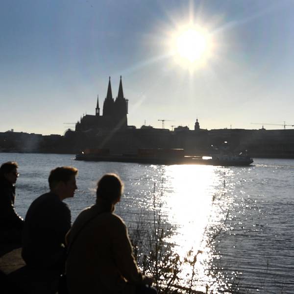 Menschen genießen die Sonne vor dem Dom. (Symbolbild)