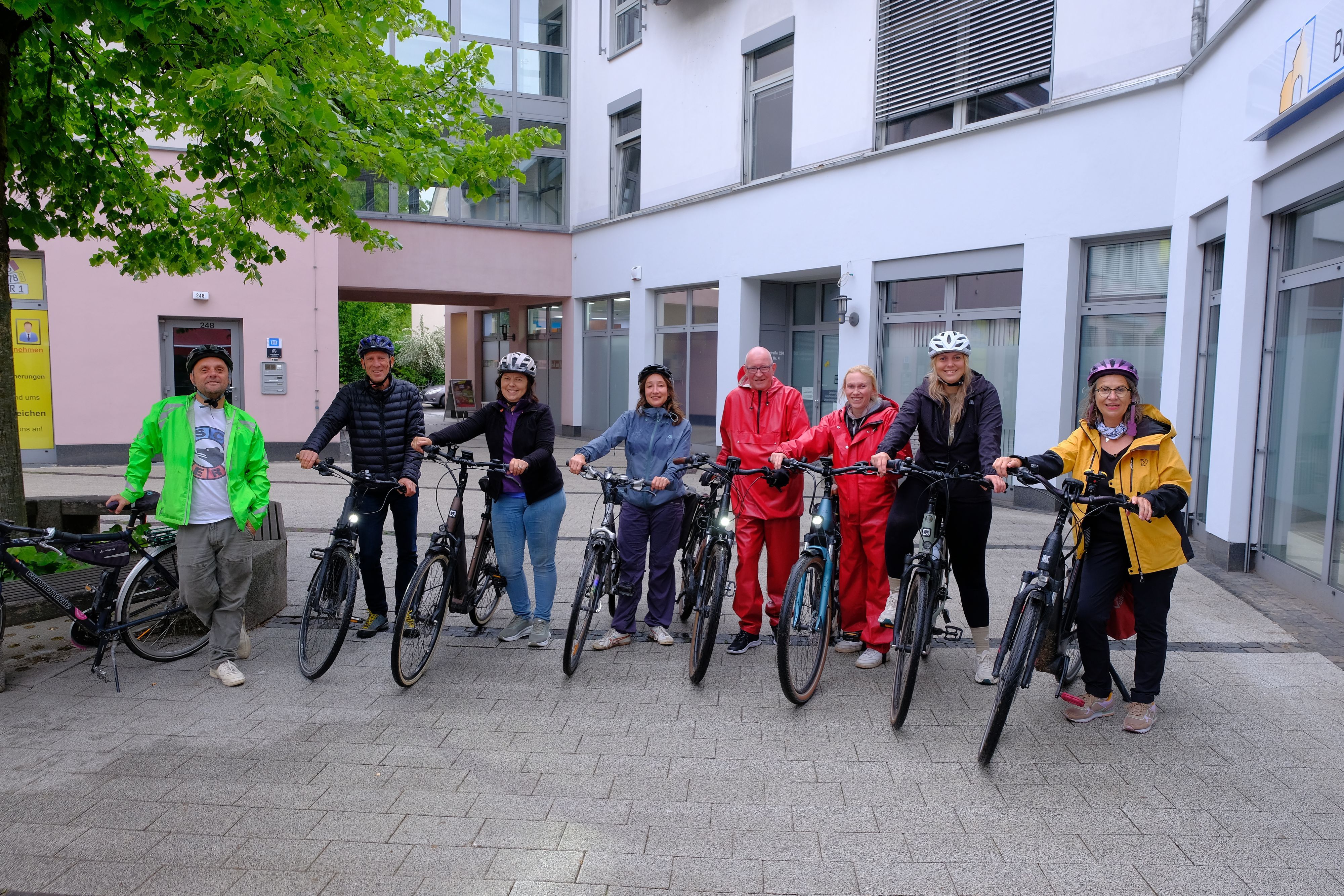 Eine Radfahrergruppe lächelt in die Kamera.