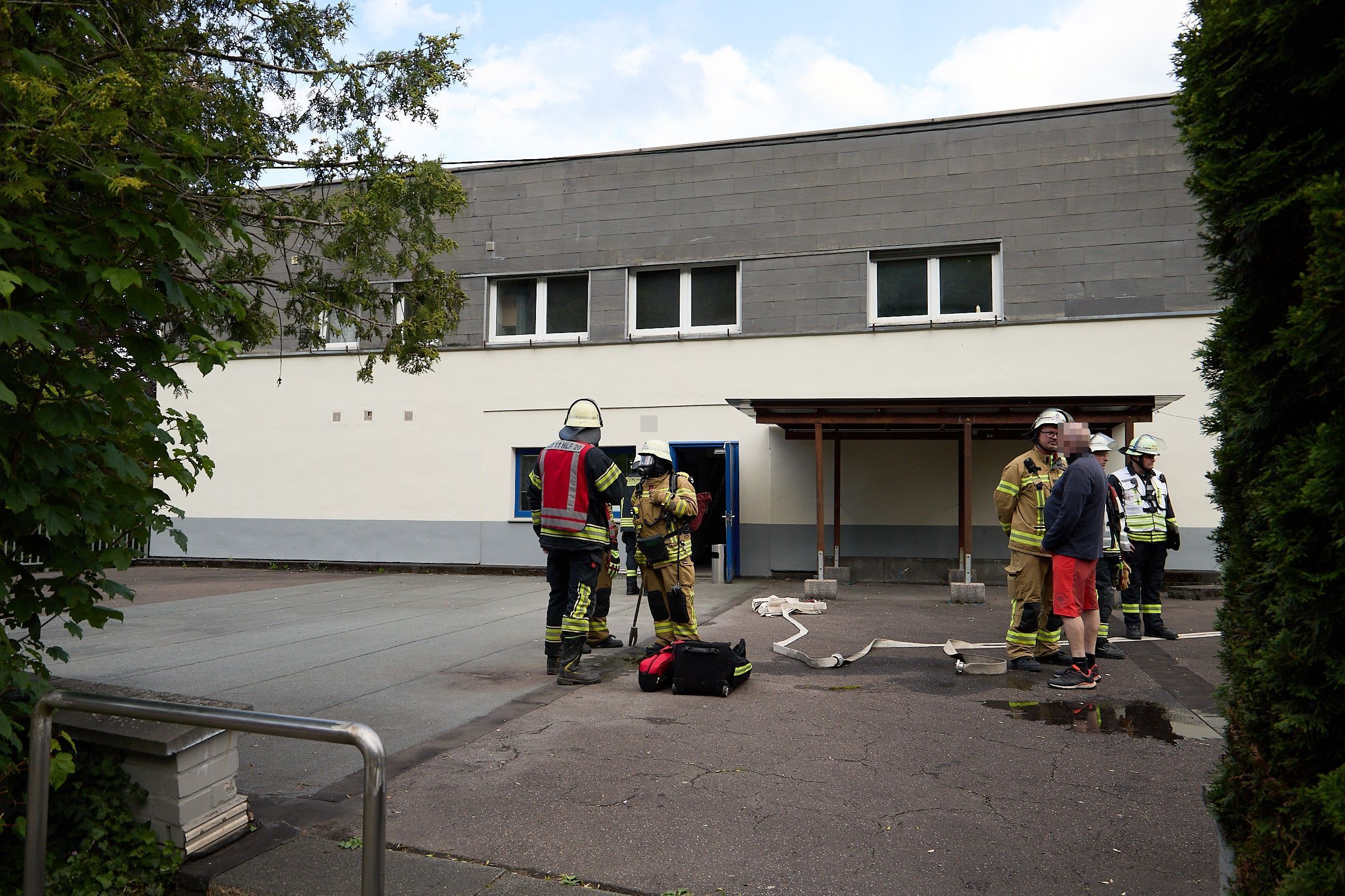 Feuerwehrleute stehen vor einem Gebäude.