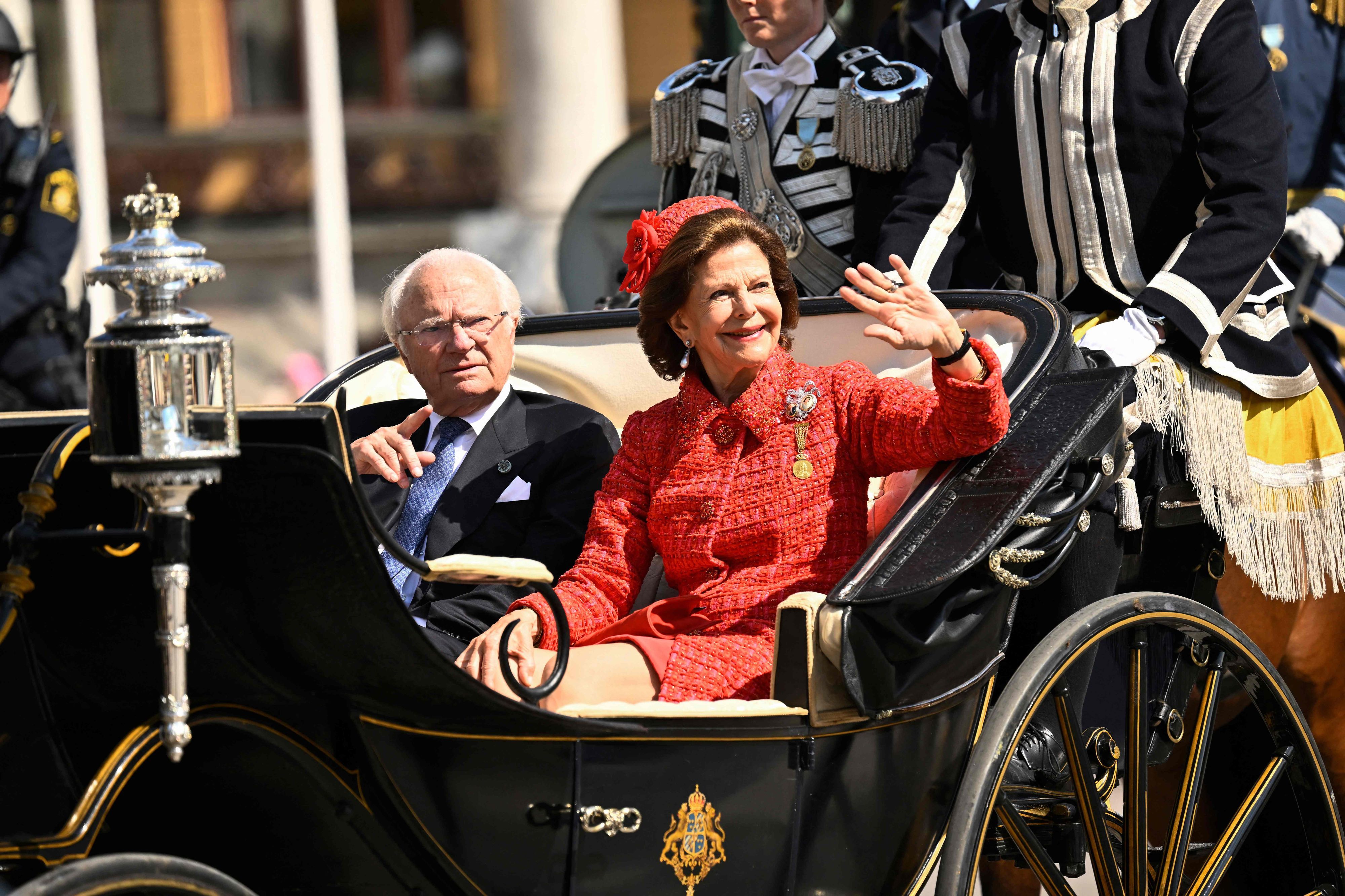 König Carl Gustaf und Königin Silvia winken in einer Kutsche.