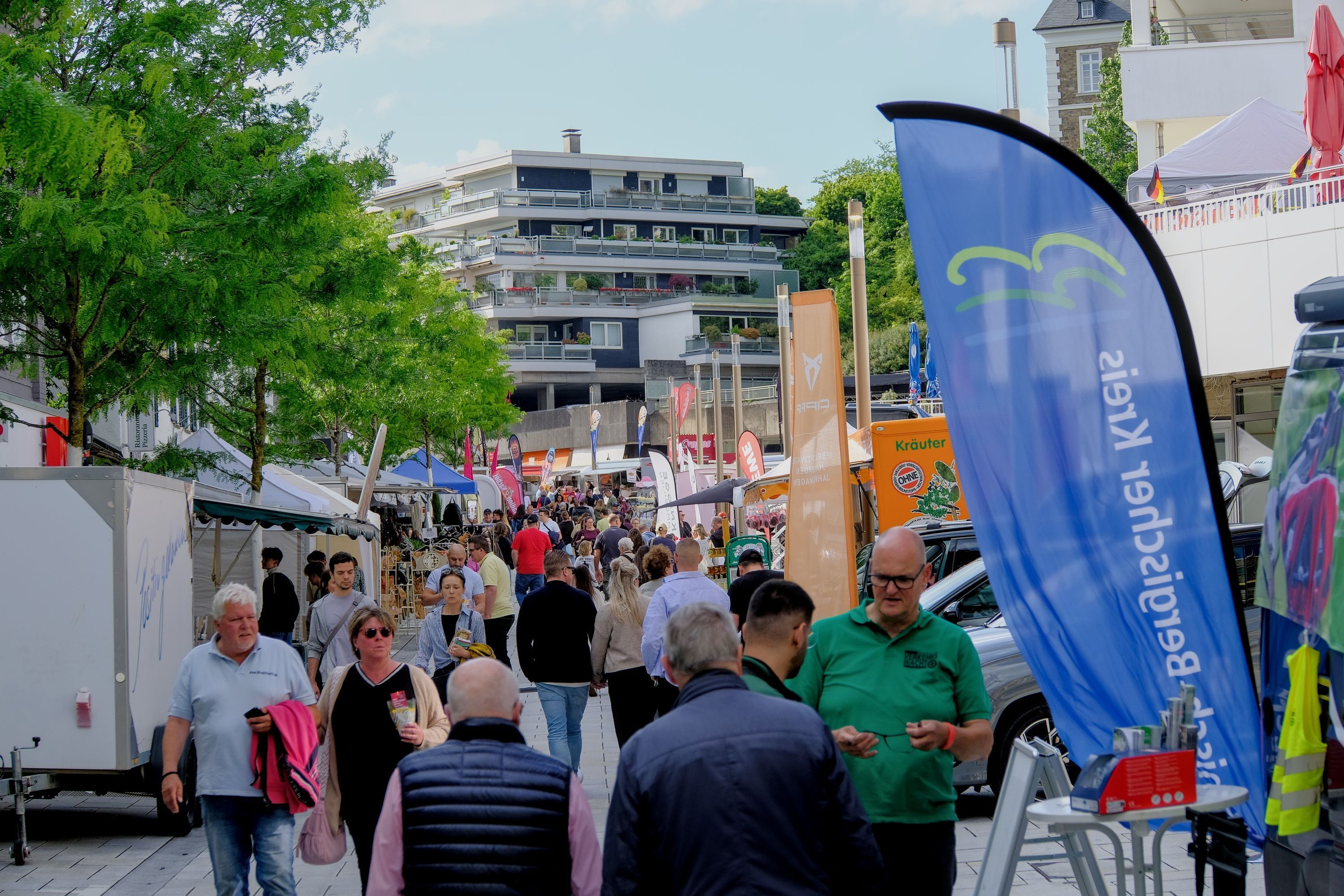 Menschen laufen bei einem Stadtfest eine Straße runter.