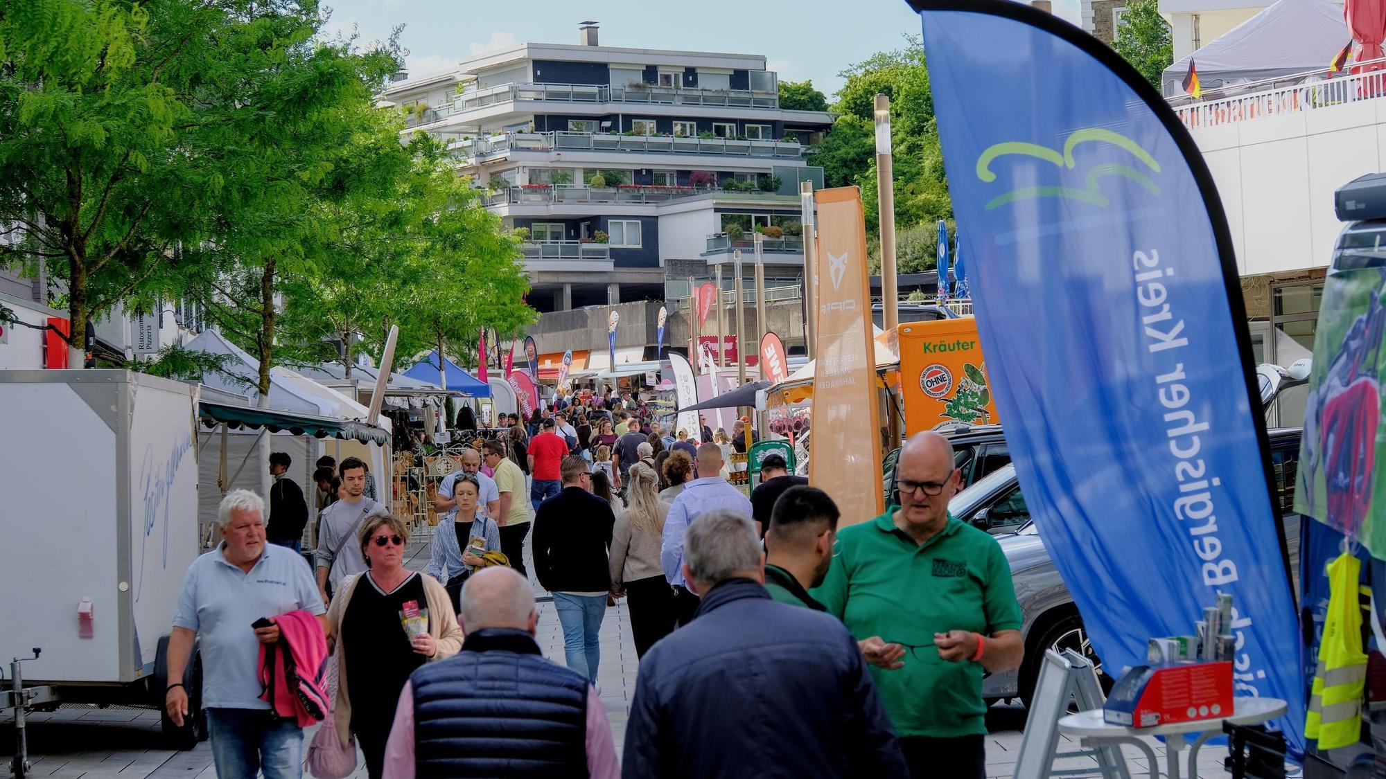 Menschen laufen bei einem Stadtfest eine Straße runter.