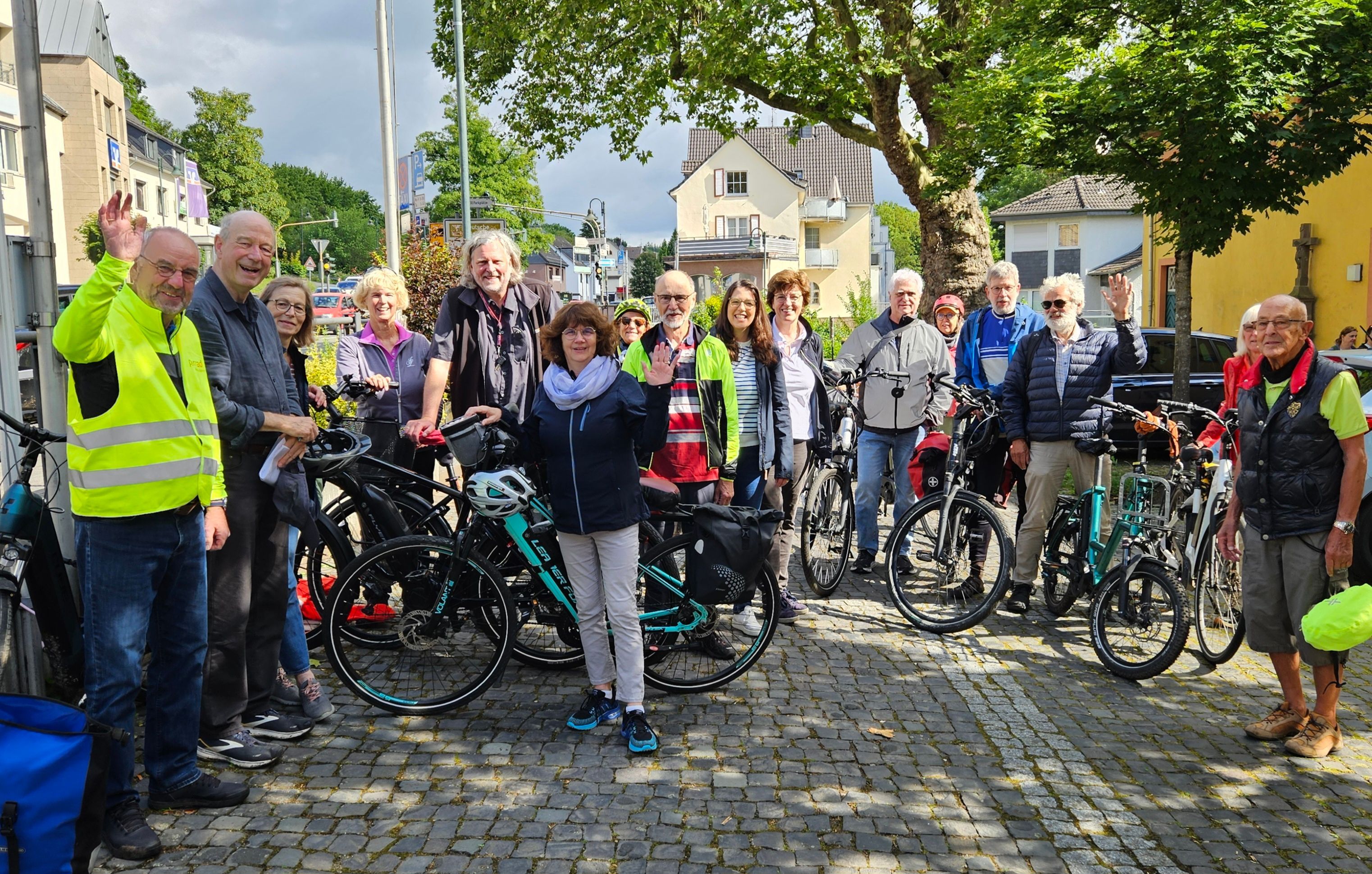 Zu sehen sind Menschen mit Fahrrädern, die freundlich in die Kamera lächeln.