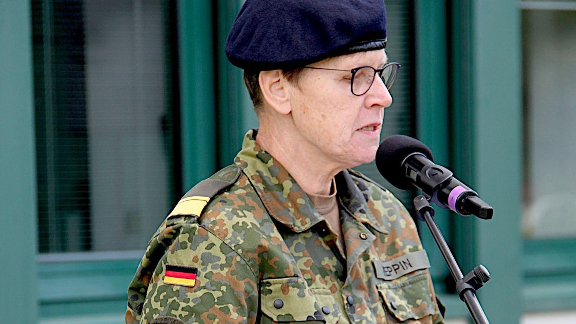 Standortälteste Sabine Reppin steht in Uniform an einem Pult und spricht in ein MIkrofon