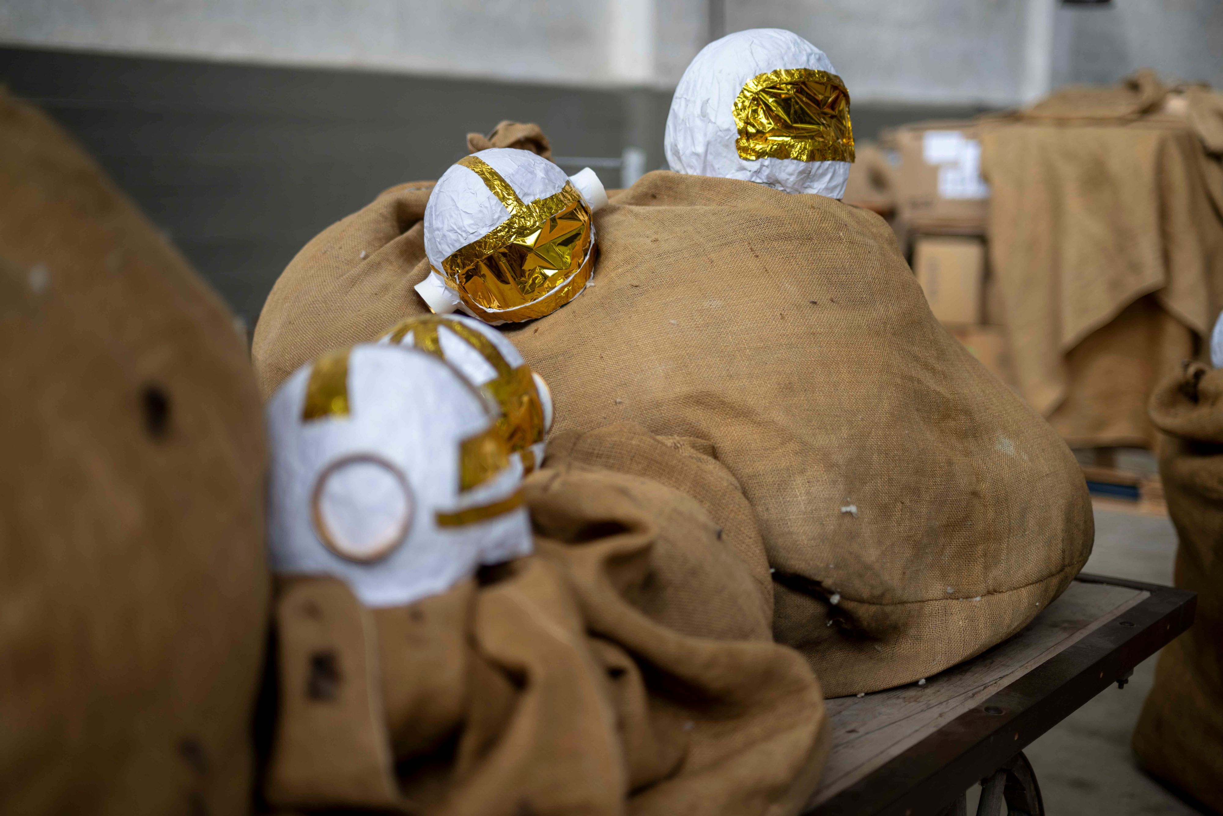 Kleine, gebastelte Astronauten-Helme liegen auf Jutesäcken.