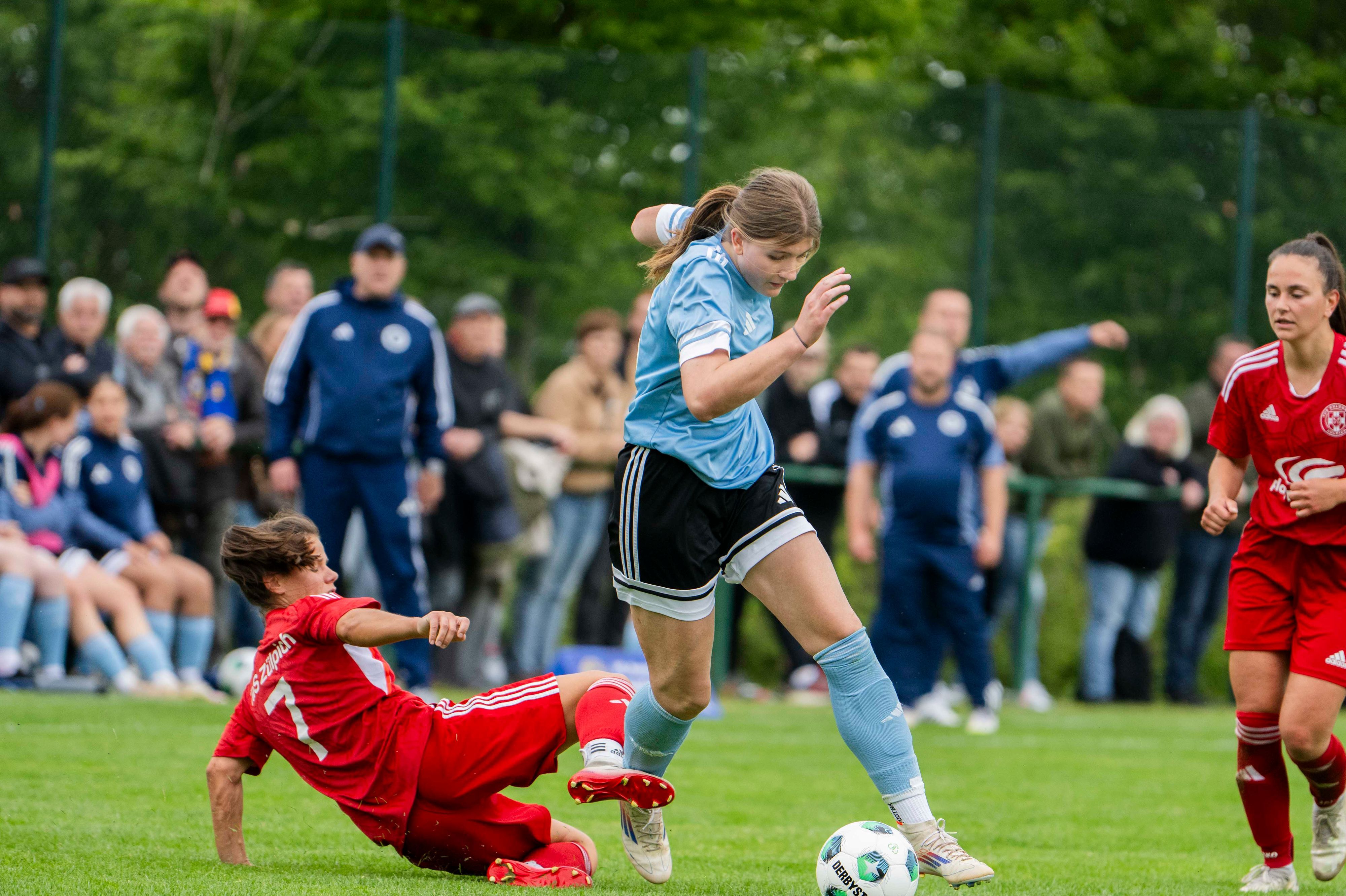 Milena Ronig grätscht in Ina Schneiders und trifft sie am Schienbein.