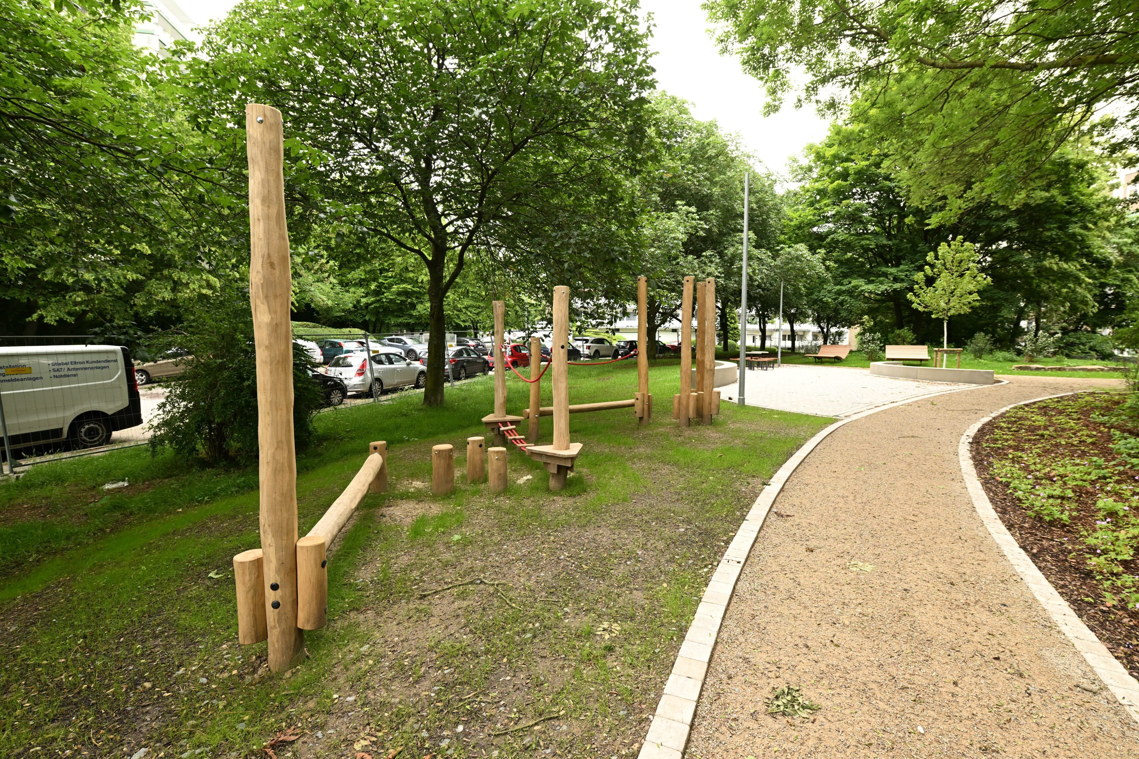 Im Park gibt es Wege aus hellbrauner Erde und einen Holzspielplatz.