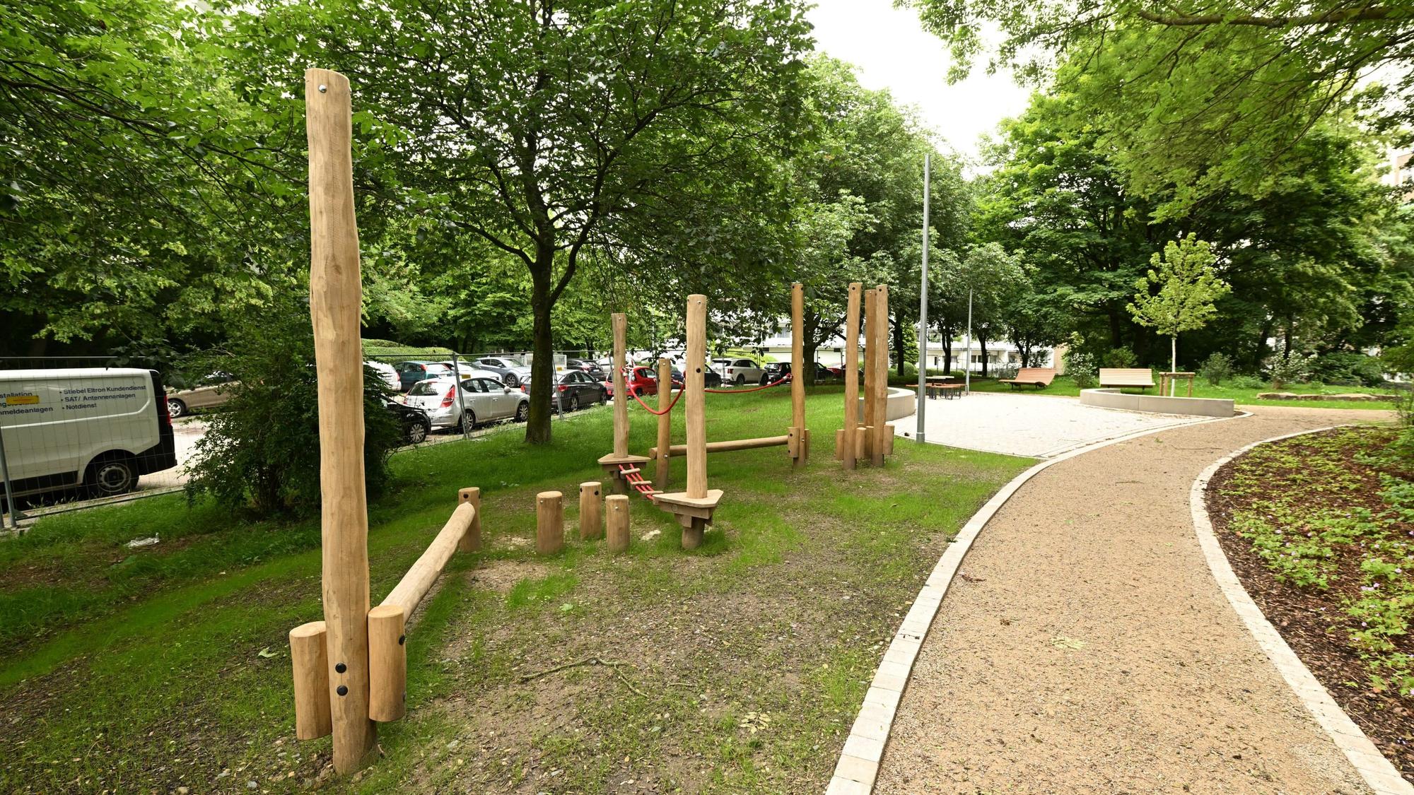 Im Park gibt es Wege aus hellbrauner Erde und einen Holzspielplatz.