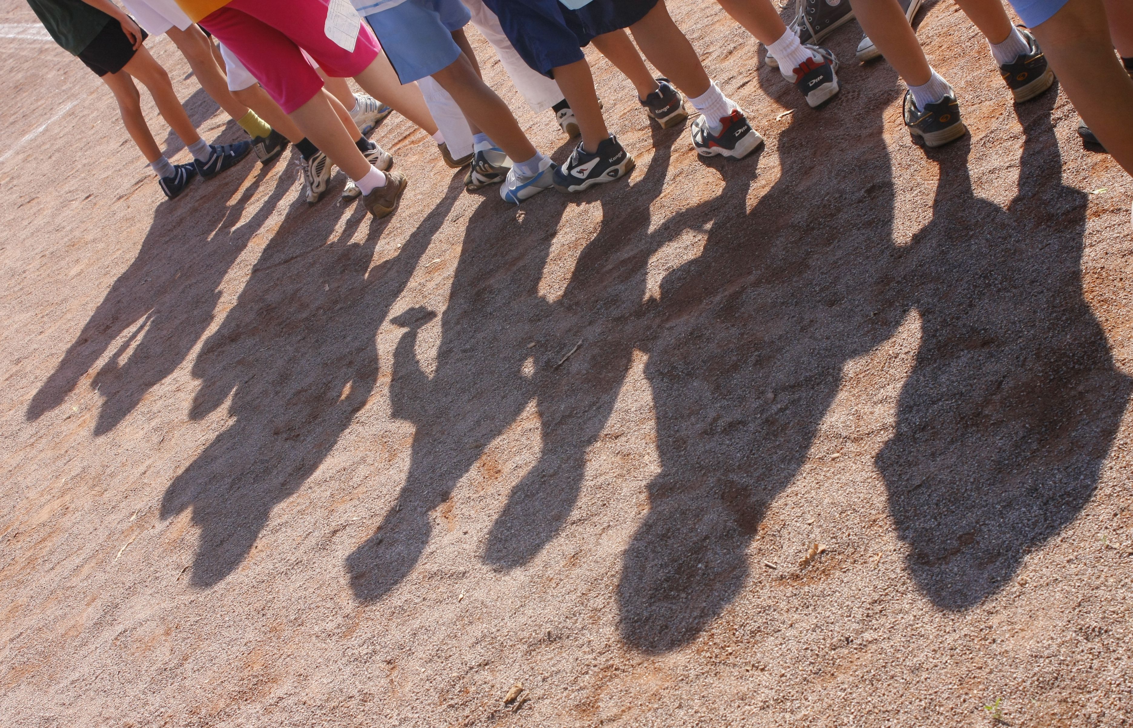 Kinder einer Grundschule stehen im Rahmen der Bundesjugendspiele auf einem Sportplatz. (Archivbild)