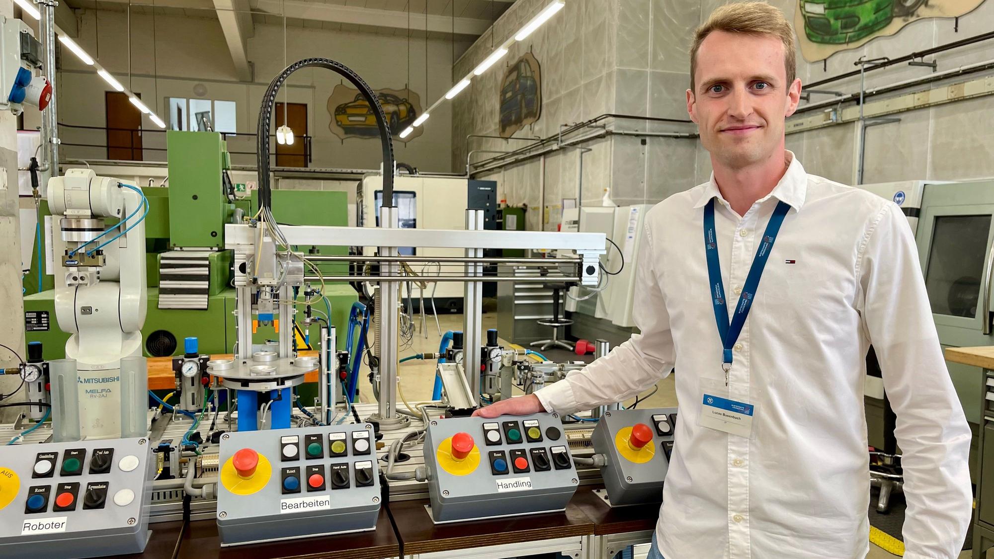 Ausbildungsleiter Lukas Biesenbach am Modulkaren Produktionssystem MPS, an dem Azubis unter anderem Steuerung und das Programmieren von Robotern lernen.