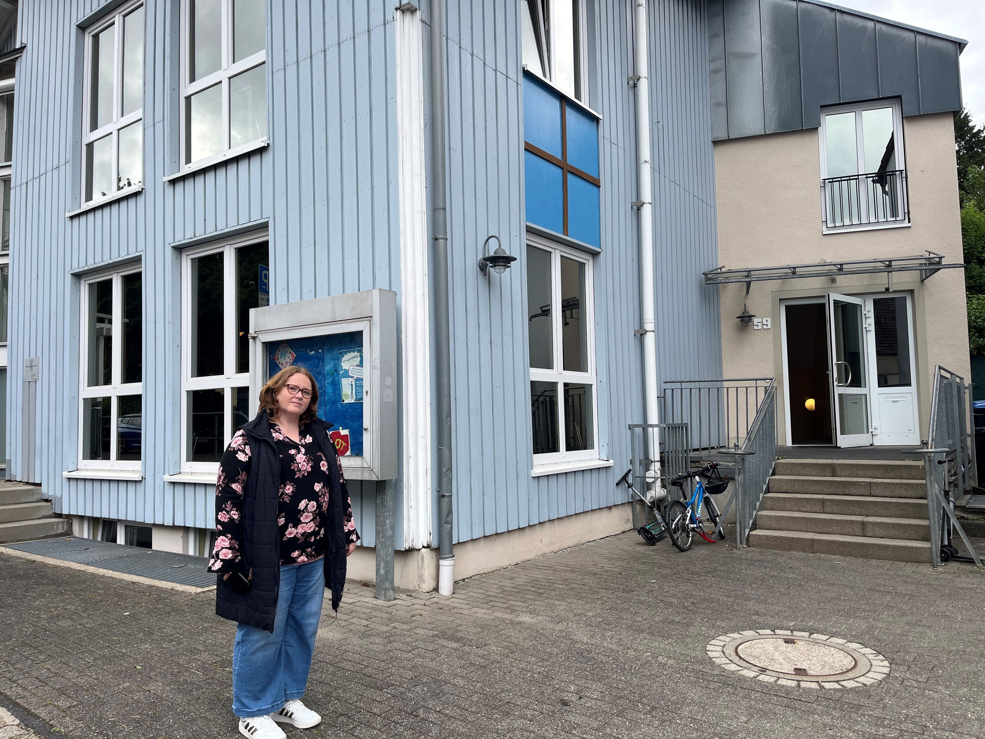 Die Mutter steht vor dem OGS-Gebäude.