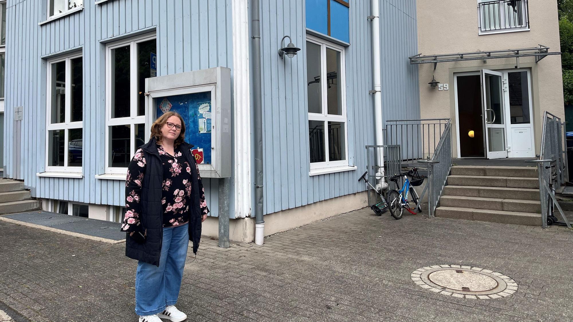 Die Mutter steht vor dem OGS-Gebäude.