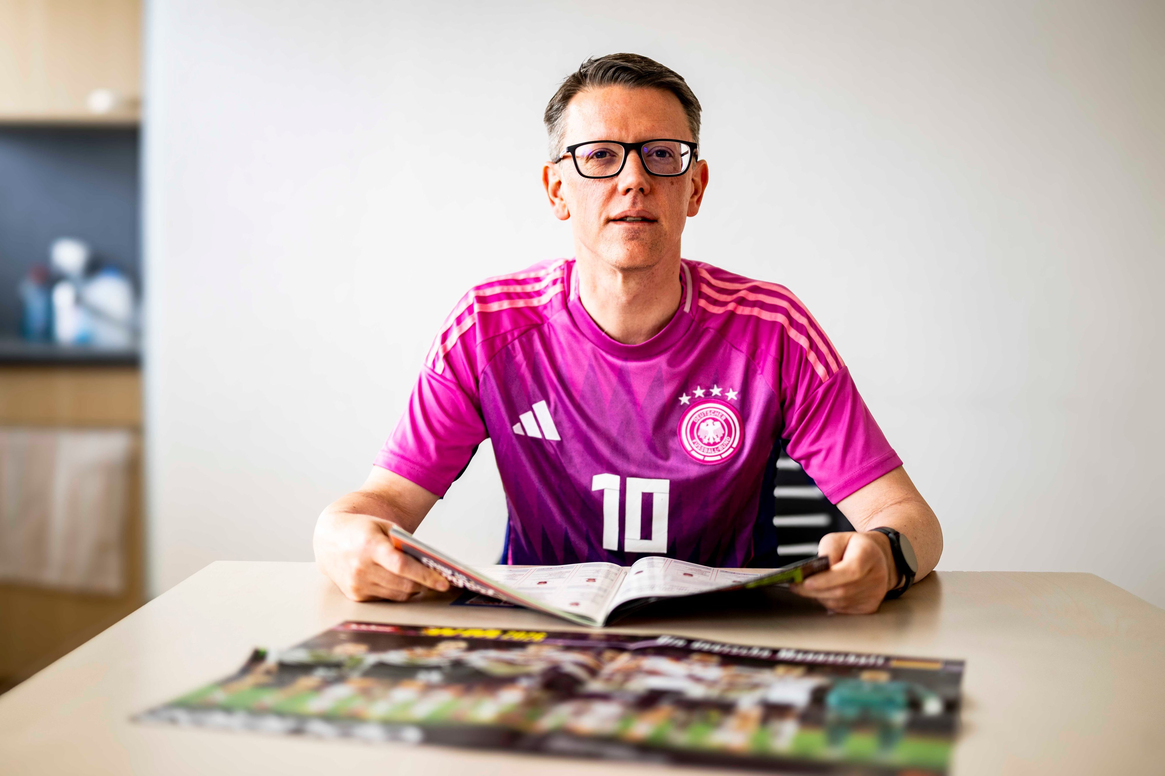Thomas Schmitz blättert im Kicker-Sonderheft.