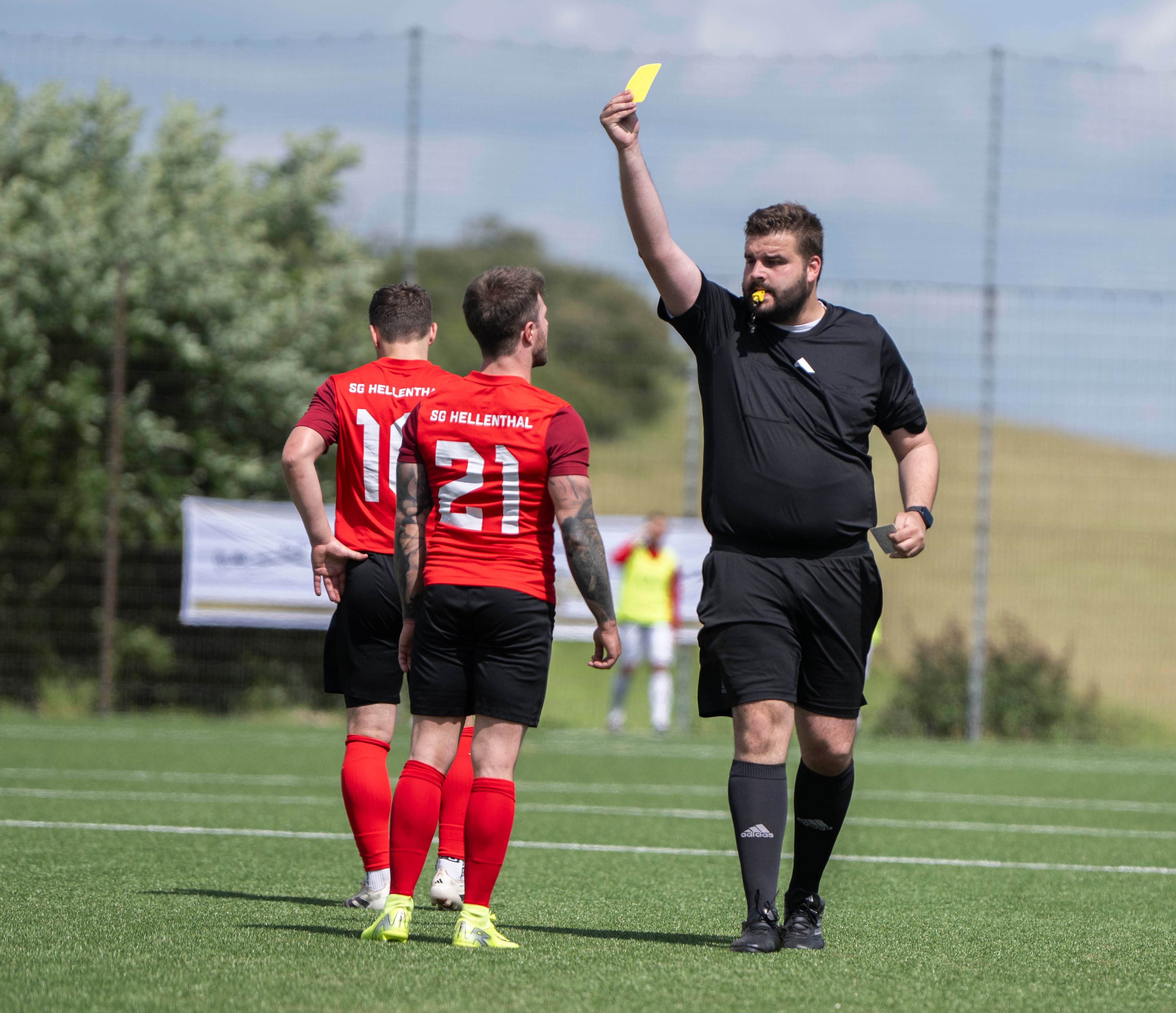 Der Schiedsrichter gibt einem Hellenthaler Spieler die Gelbe Karte.