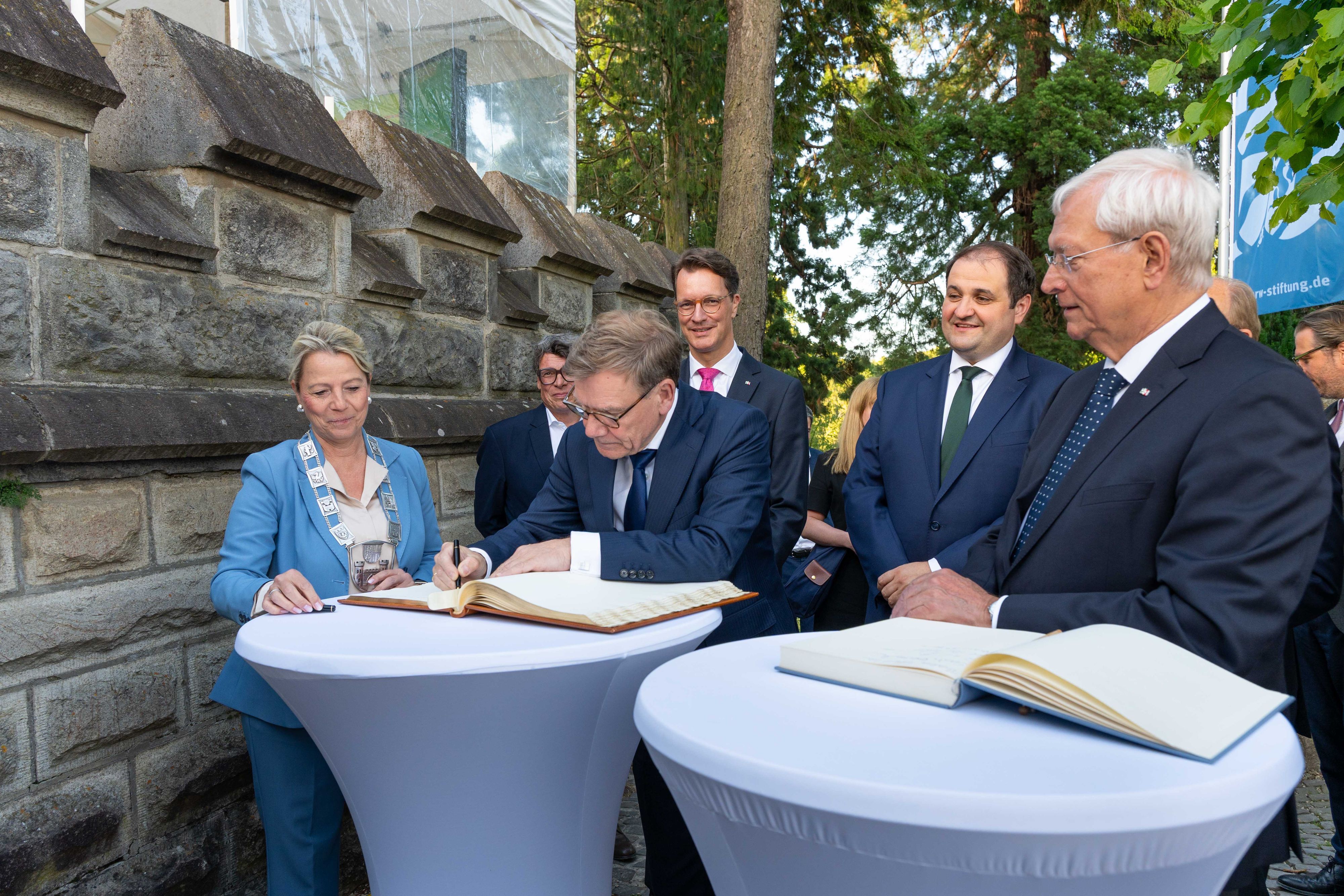 Außenminister Johann Wadephul (CDU) trägt sich beim Sommertreff der NRW-Stiftung auf Schloss Drachenburg ins Gästebuch ein. Links neben ihm die Bürgermeisterin von Königswinter, Heike Jüngling (CDU). Weiter sind auf dem Bild: KStA-Chefredakteur Gerald Selch (verdeckt), NRW-Ministerpräsident Hendrik Wüst, der Chef der Staatskanzlei in Düsseldorf, Nathanael Liminski, und Eckhard Uhlenberg, Präsident der NRW-Stiftung (alle drei CDU, von links)