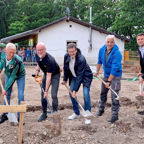 Die sechs Männer, die in einer Reihe stehen, werfen mit Spaten Erde in die Luft.