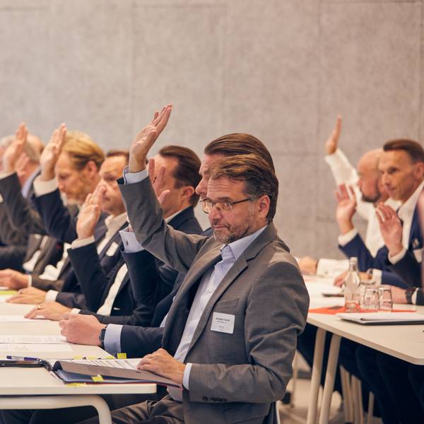 Die Vertreter der an der Initiative beteiligten Unternehmen signalisieren mit erhobenen Händen ihre Zustimmung zur Satzung