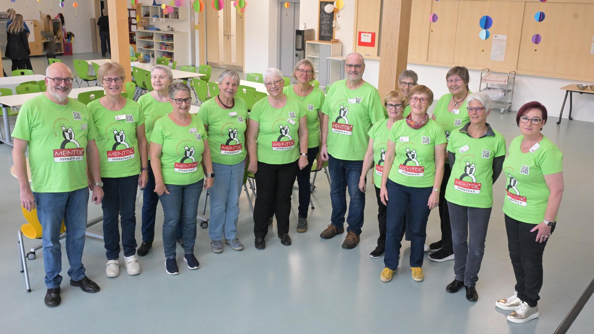 Eine Gruppe von Männern und Frauen steht zusammen mit einheitlichen T-Shirts und schaut in eine Kamera.