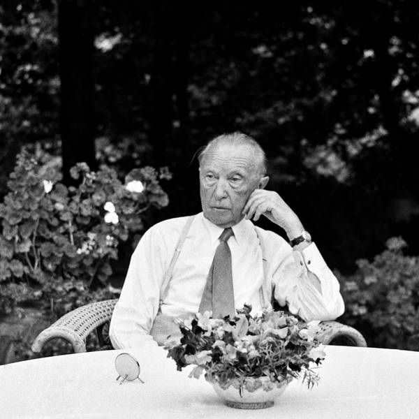 Konrad Adenauer sitzt an einem Tisch.