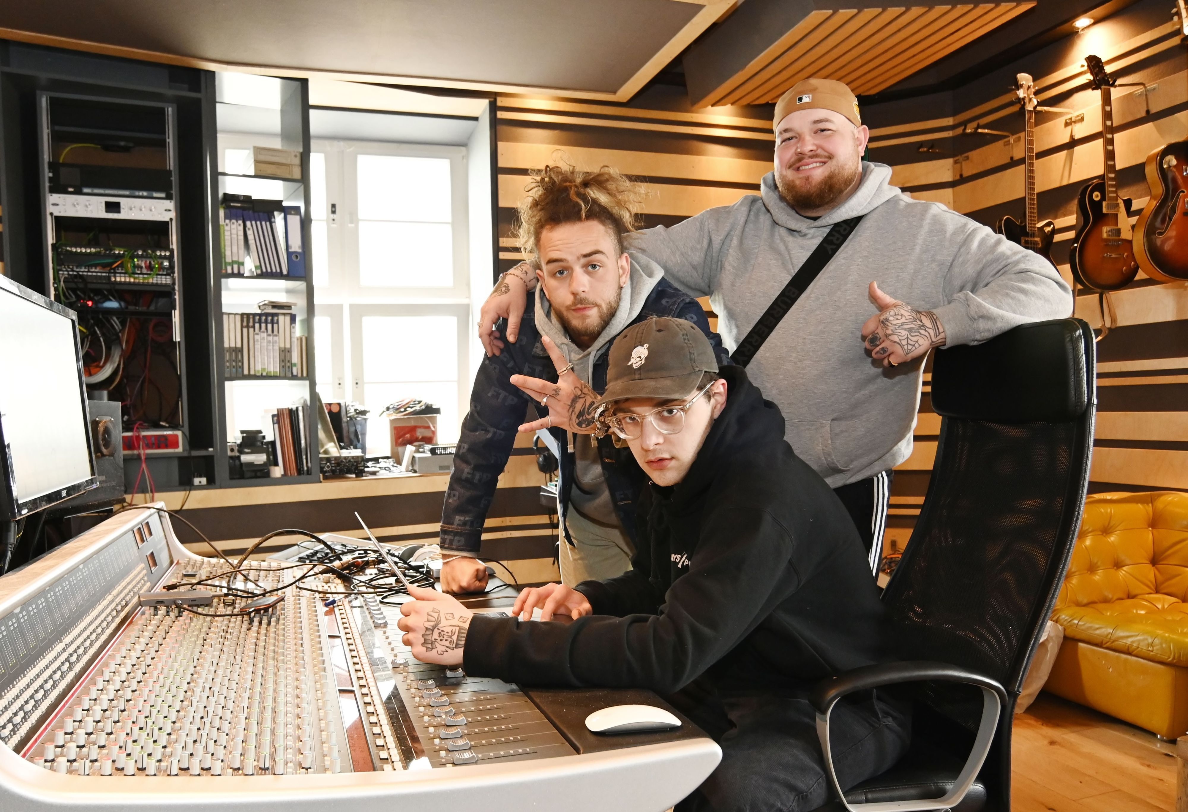 Kinder der Küste alias Lugatti & 9nine im Studio. Produzent Felix T. alias Traya (schwarzes Käppi, sitzend), Luca J. alias Lugatti (gelbes Käppi, graues Shirt) und Tobi U. alias 9inebro.