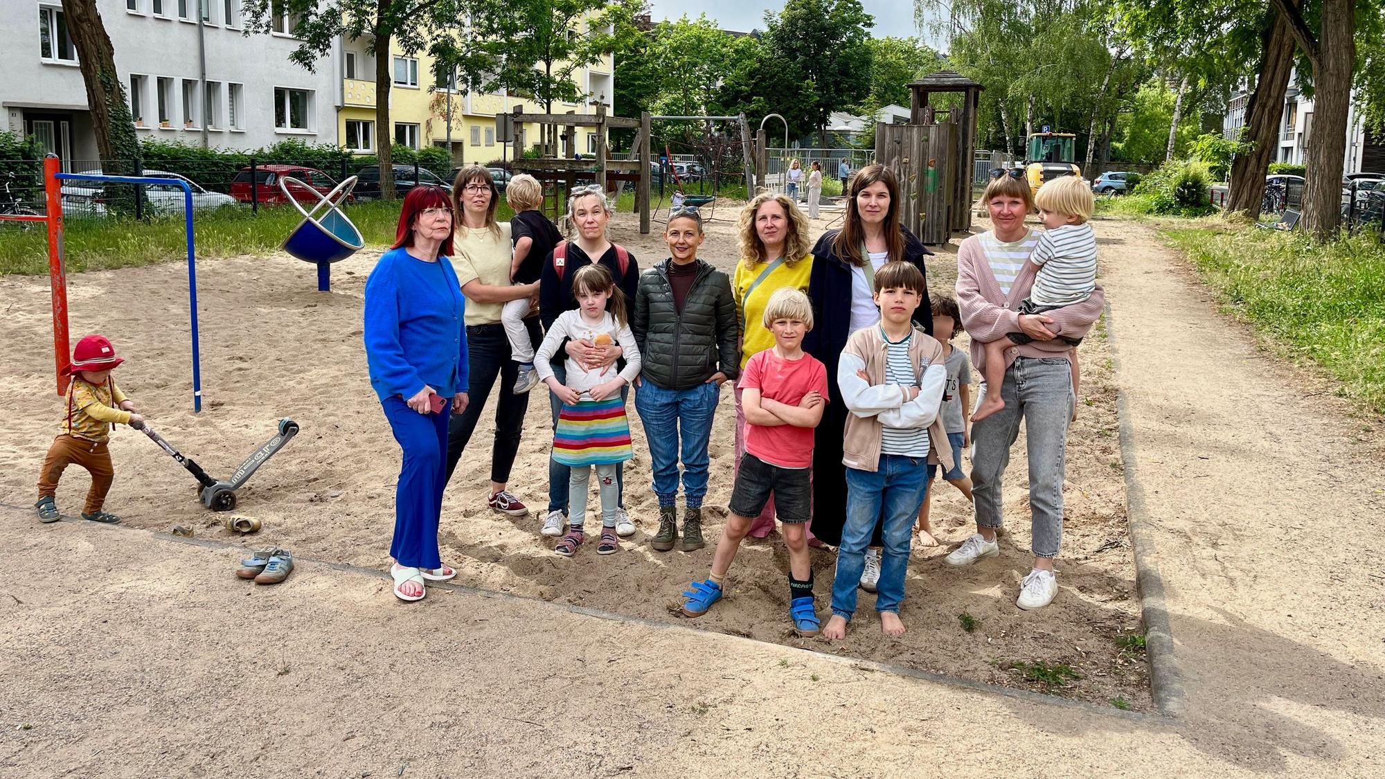 Anwohnerinnen und ihre Kinder auf dem Spielplatz Münstereifeler Platz. Auf dem Areal vor dem Sandkasten, an dem sie stehen, sollen die Container aufgestellt werden.