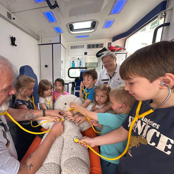 Der Verein Sankt Augustin hilft erklärt Kindern aus der Kita Bismarckplatz wie ein Rettungswagen funktioniert. Gunter Maassen (l.) erklärt die Funktionsweise eines Stethoskops.