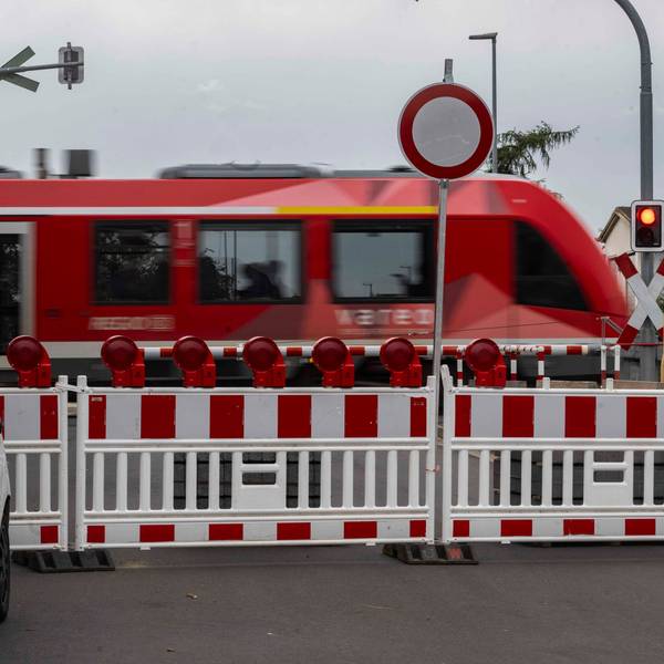 Das Bild zeigt einen Zug, der den Bahnübergang passiert.