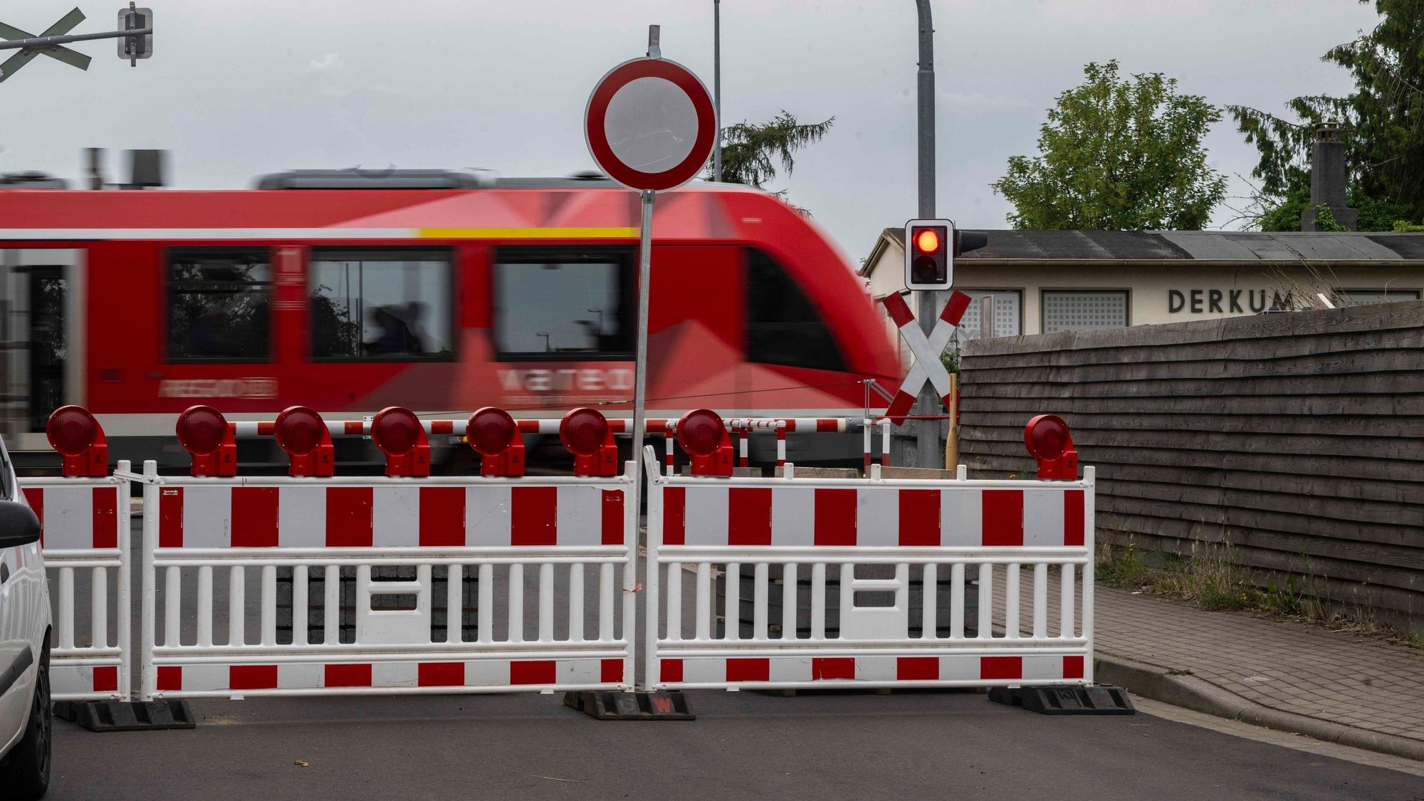Das Bild zeigt eine Regionalbahn, die den Bahnübergang passiert.
